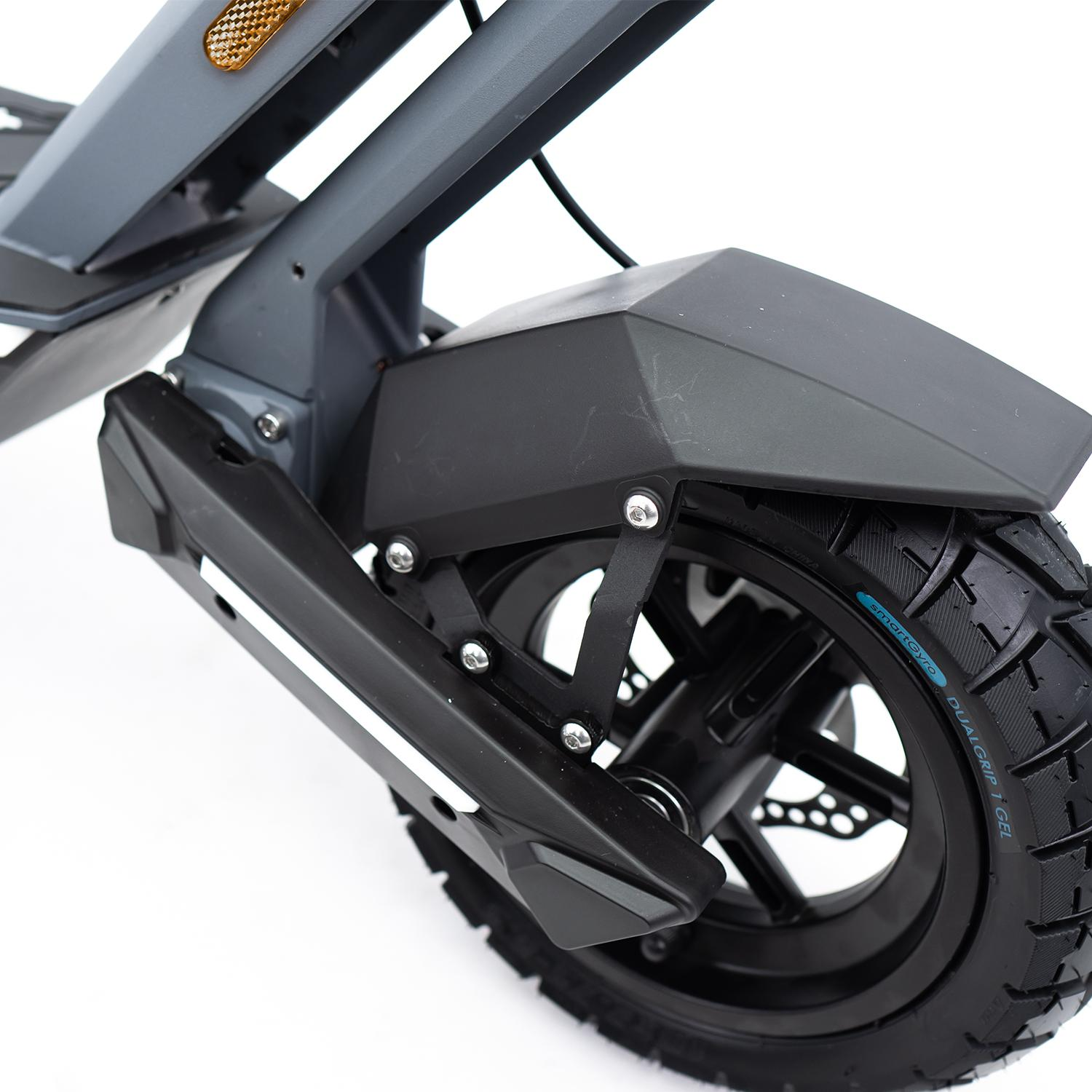 Primer plano de rueda, guardabarros y suspensión de scooter negro y gris sobre fondo blanco.