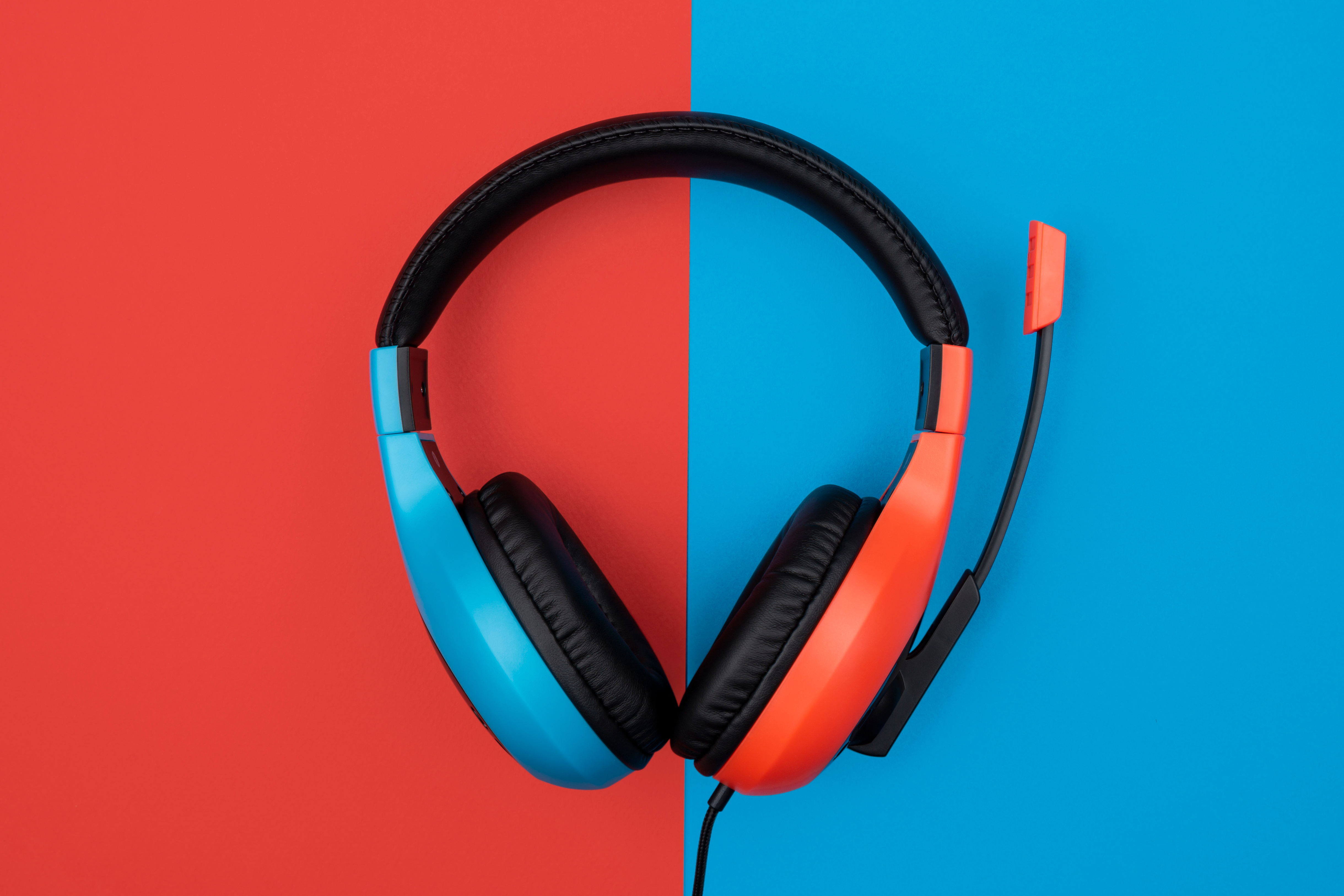 Cuffie, design diviso: blu a sinistra, arancione a destra, su sfondo diviso.