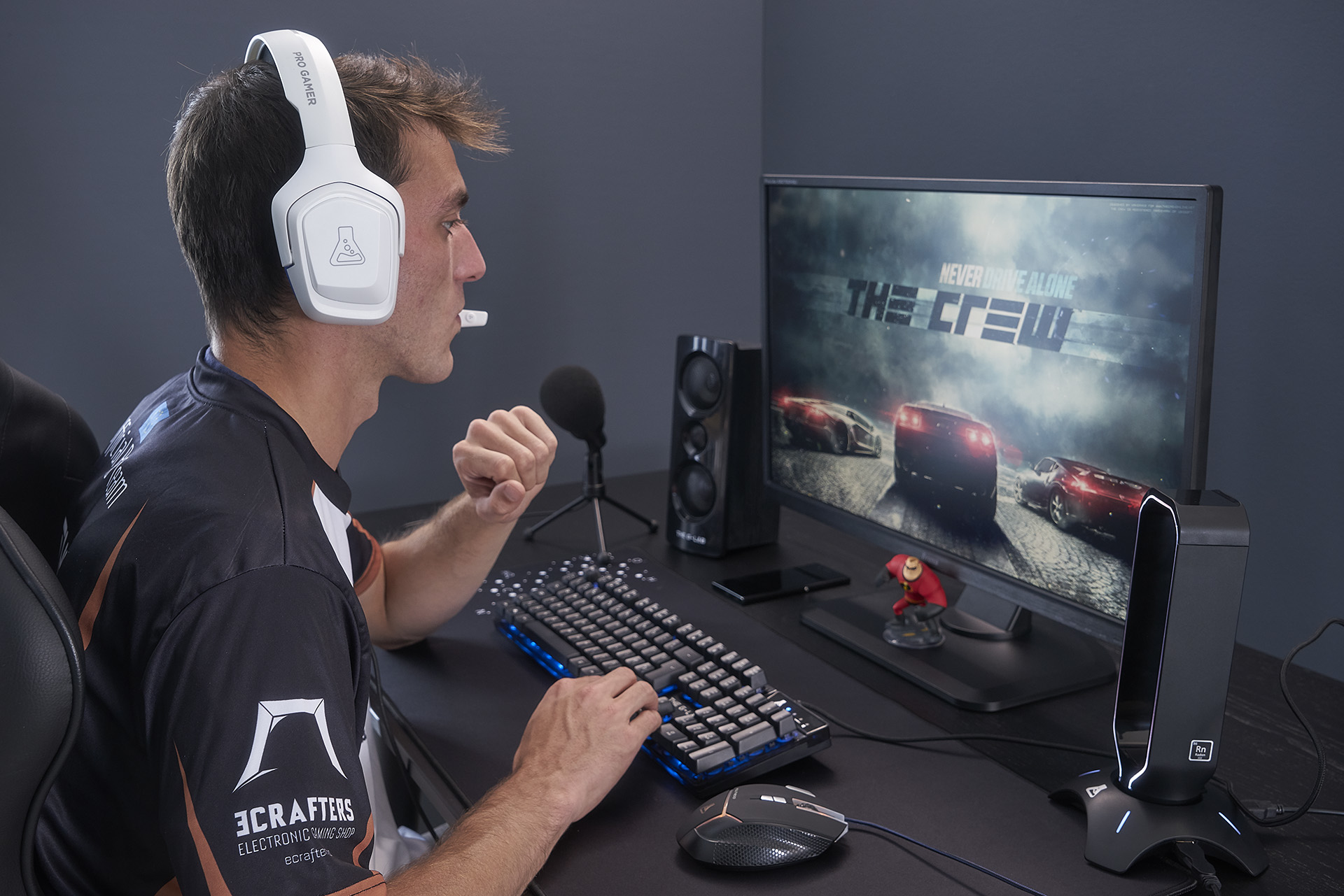 Mężczyzna gra w grę wideo. Ma na sobie białe słuchawki i patrzy na monitor.