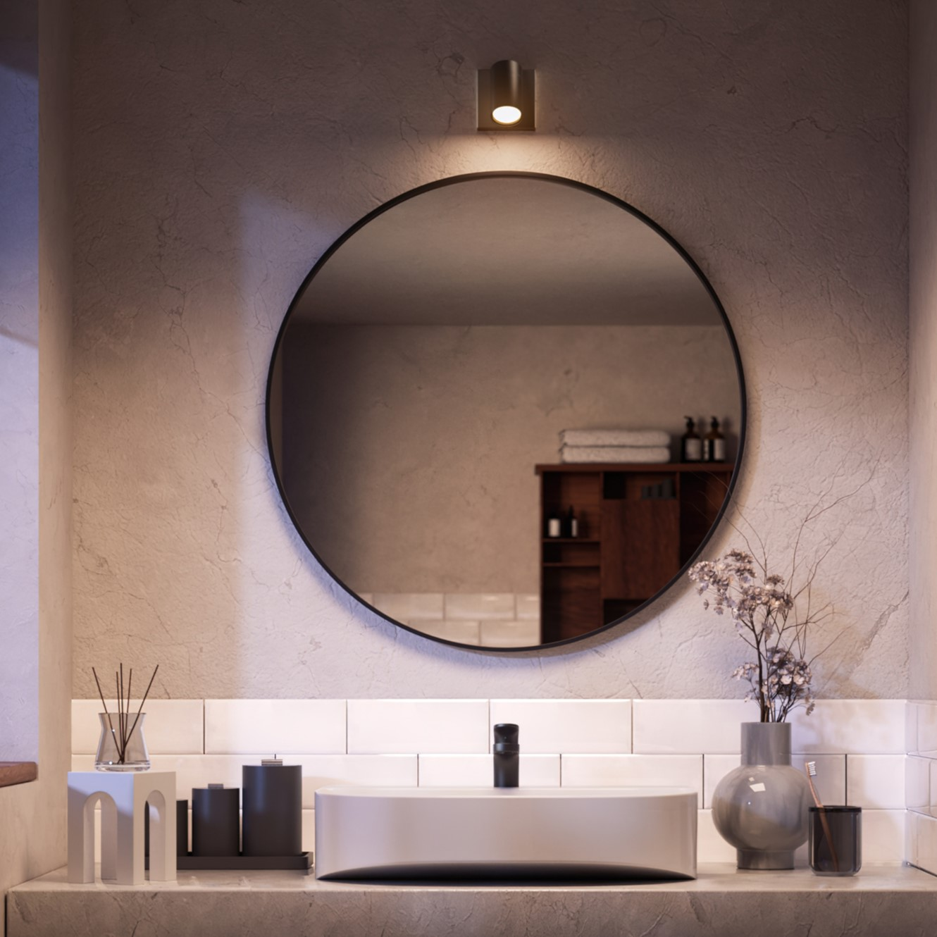 Badkamer met ronde spiegel, wastafel en decoratieve elementen.