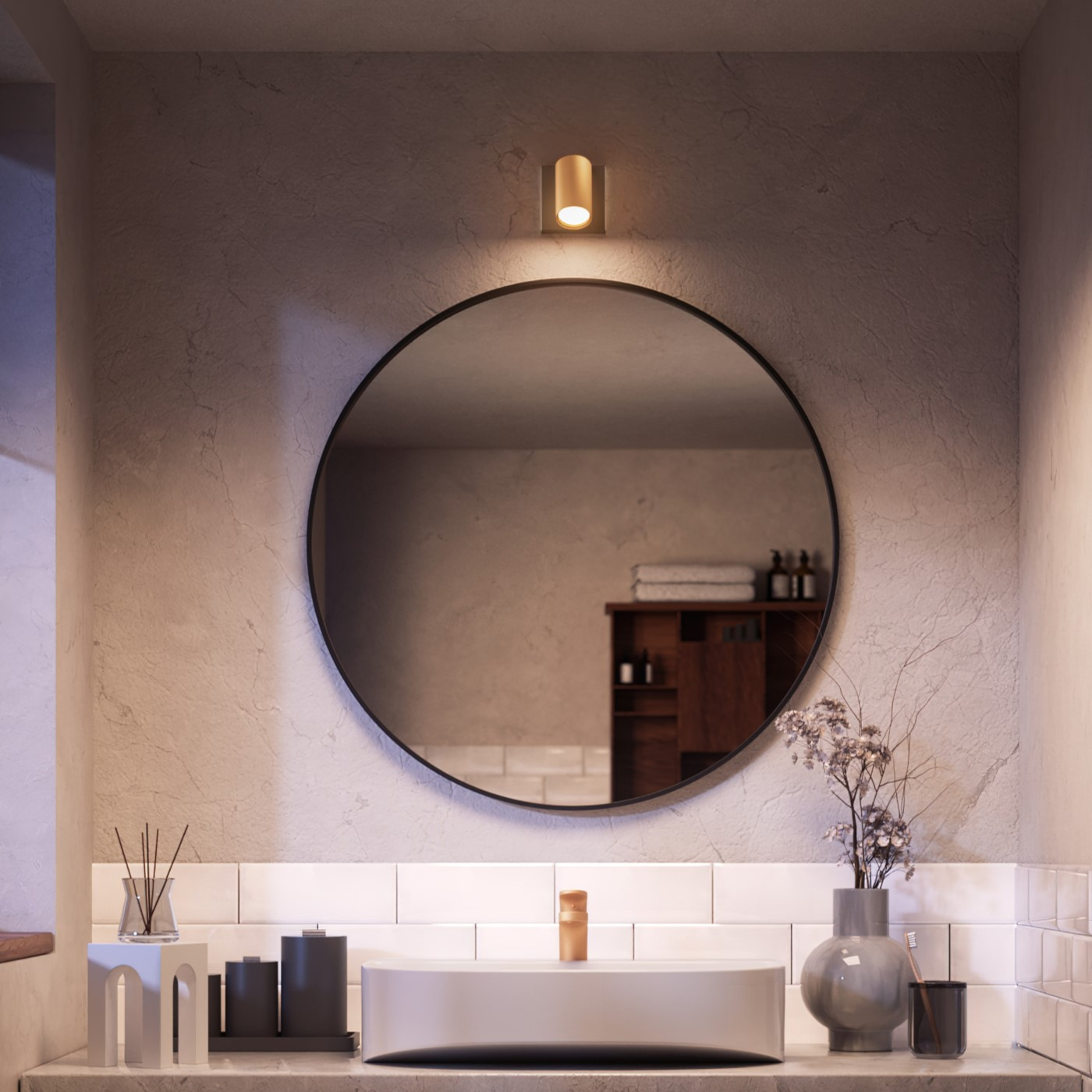 Een badkamer met een grote ronde spiegel boven een wastafel en een lamp.