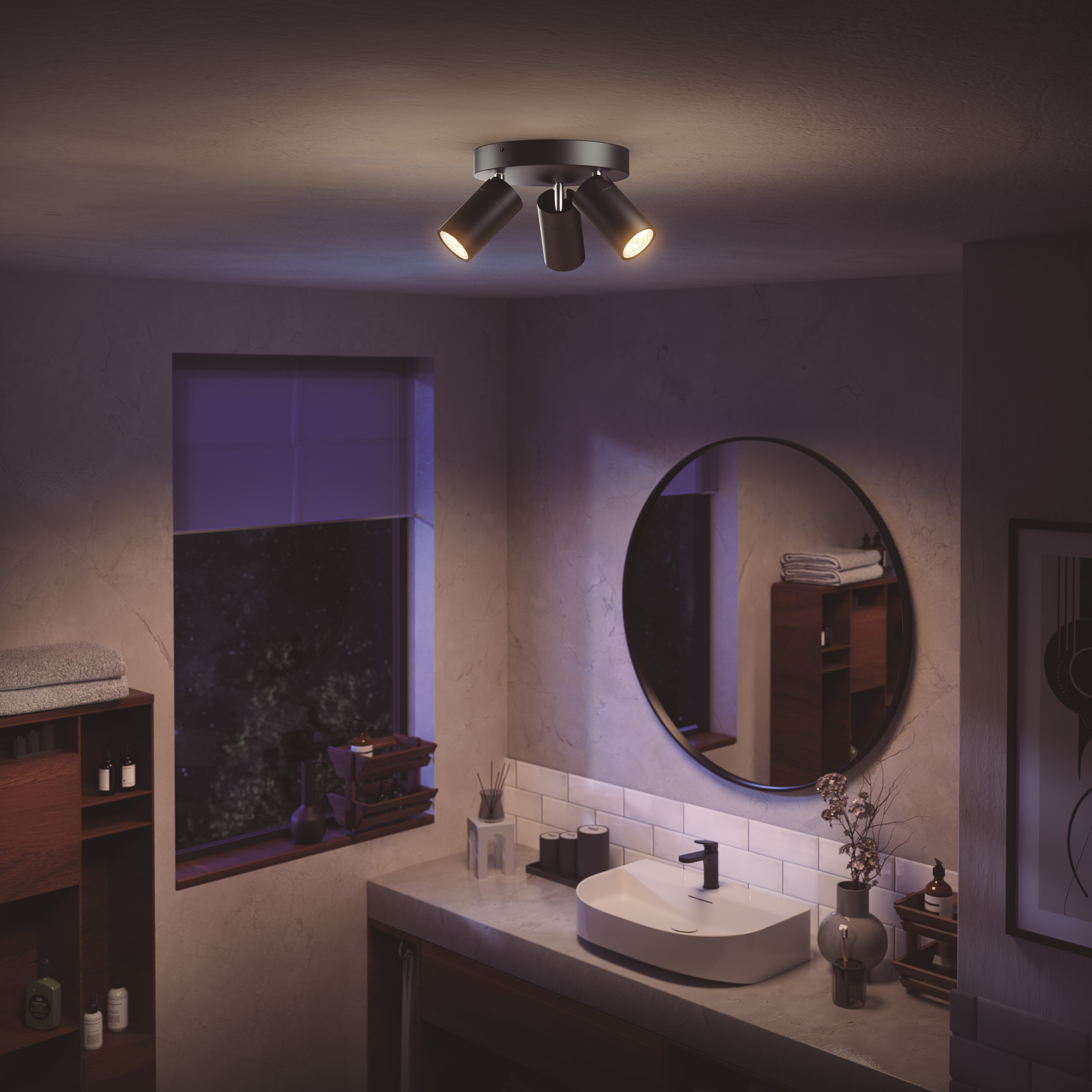 Drie witte spots met drie Hue-lampen en een witte schakelaar. Alles op een wit oppervlak.