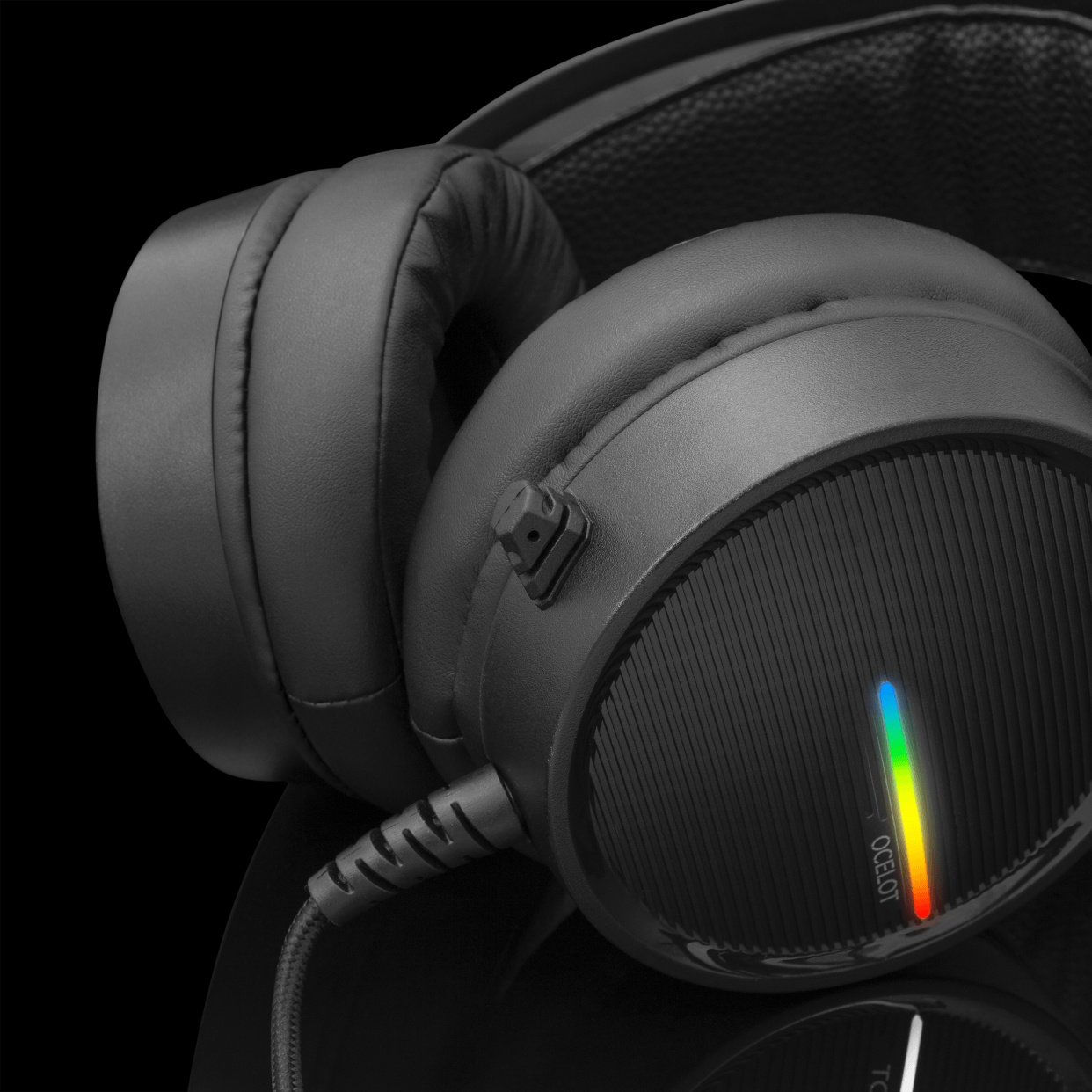 Czarne słuchawki z tęczowym światłem z boku. Czarna powierzchnia.