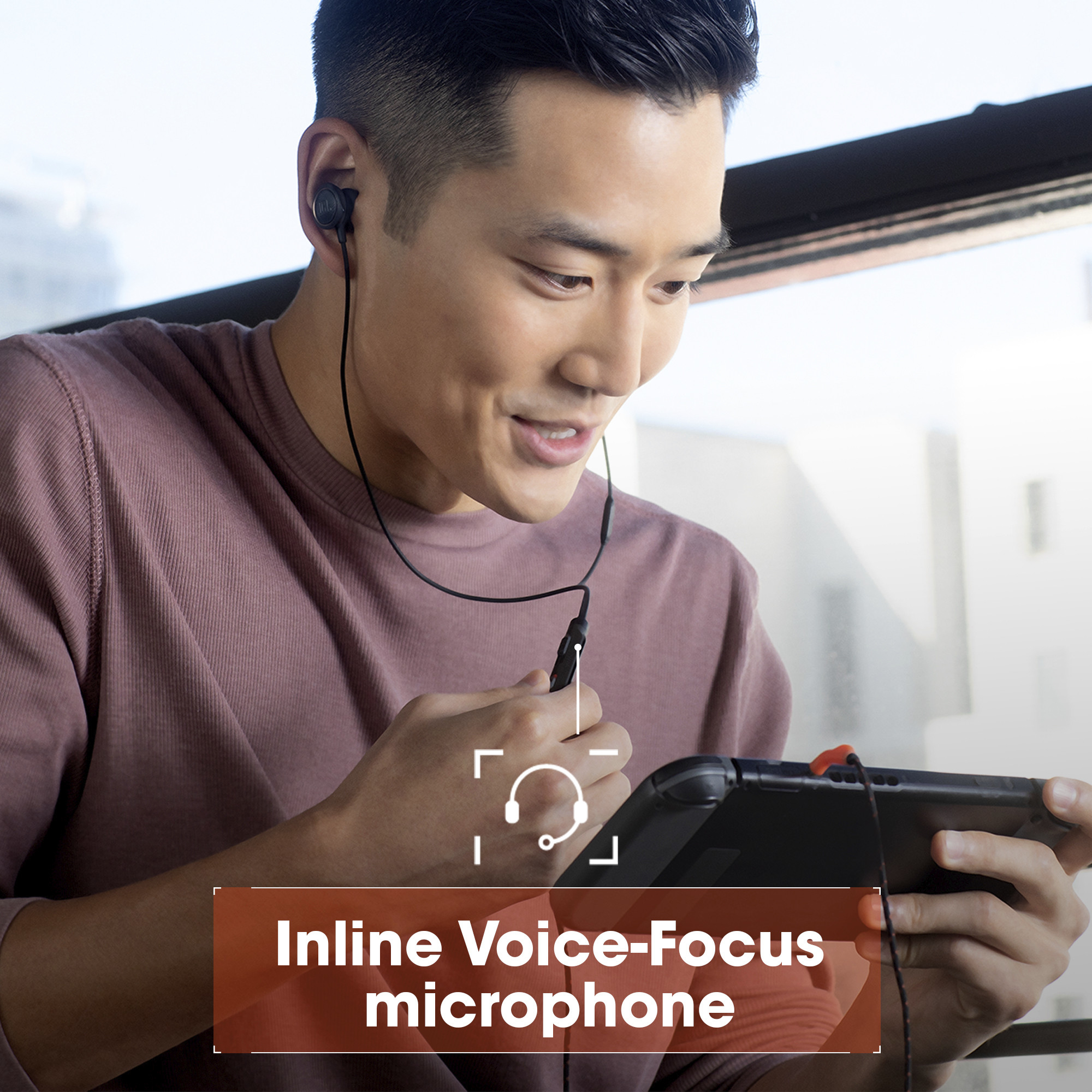 Hombre con auriculares y micrófono jugando en una consola portátil.