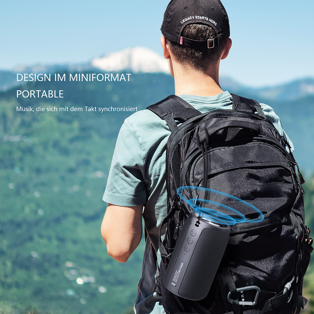 Eine Person mit Rucksack trägt einen tragbaren Lautsprecher. Der Hintergrund ist eine verschwommene Berglandschaft.