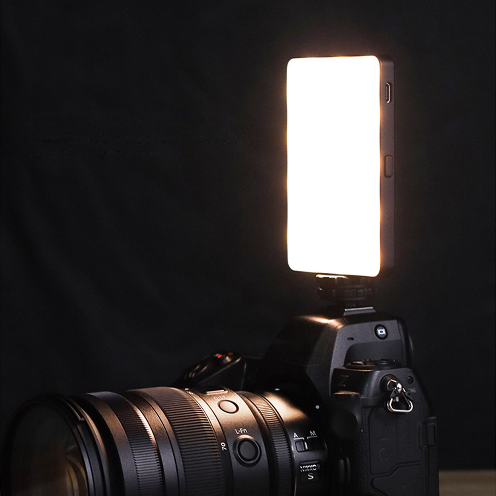 Eine Kamera mit aufgesetztem Licht. Das Licht ist hellweiß und rechteckig.