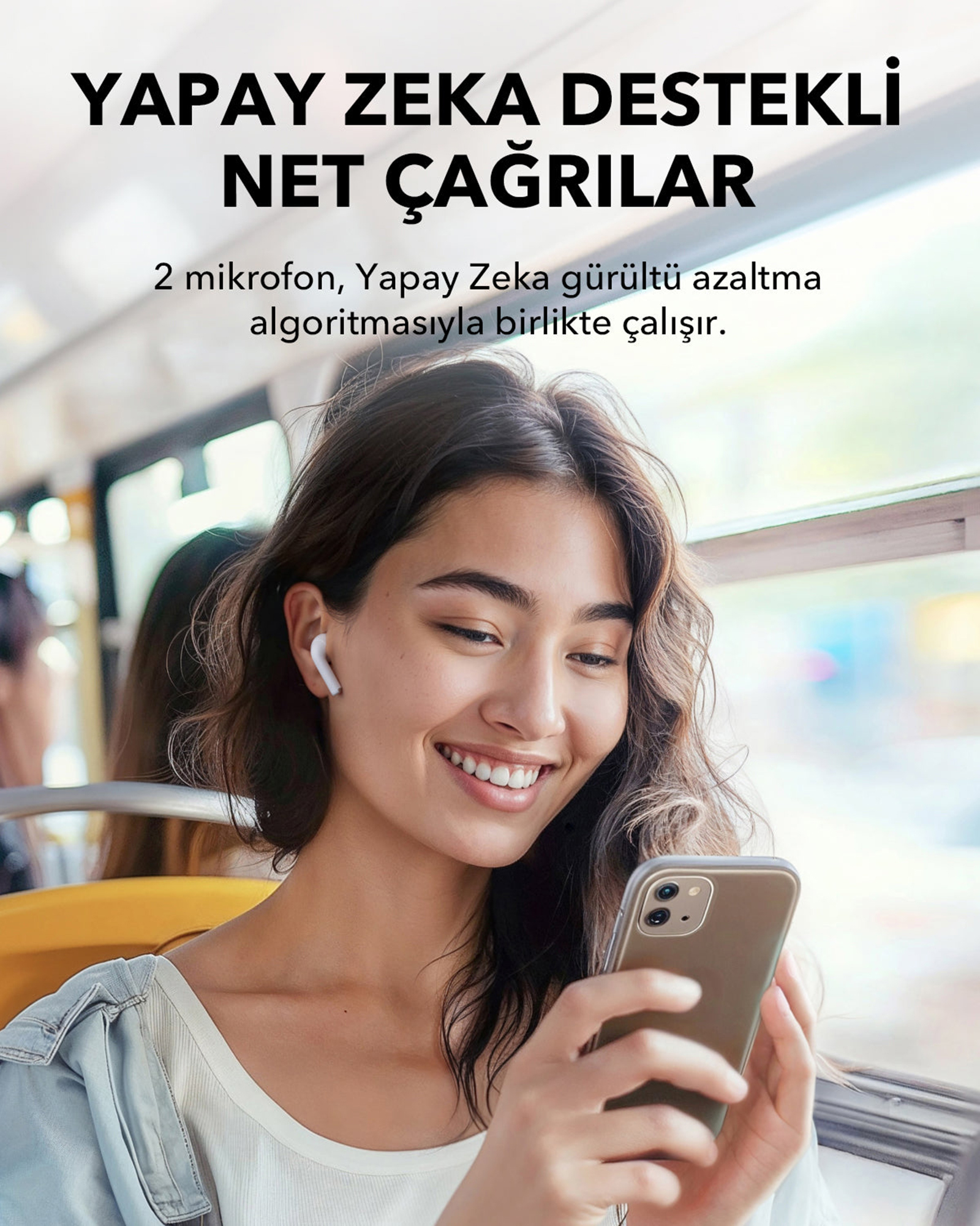Uśmiechnięta kobieta w pociągu trzyma telefon, nosi słuchawki douszne, a nad nią znajduje się turecki tekst.