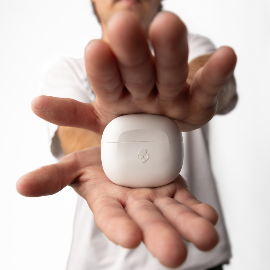 Osoba trzymająca białe etui na słuchawki, wyśrodkowane.