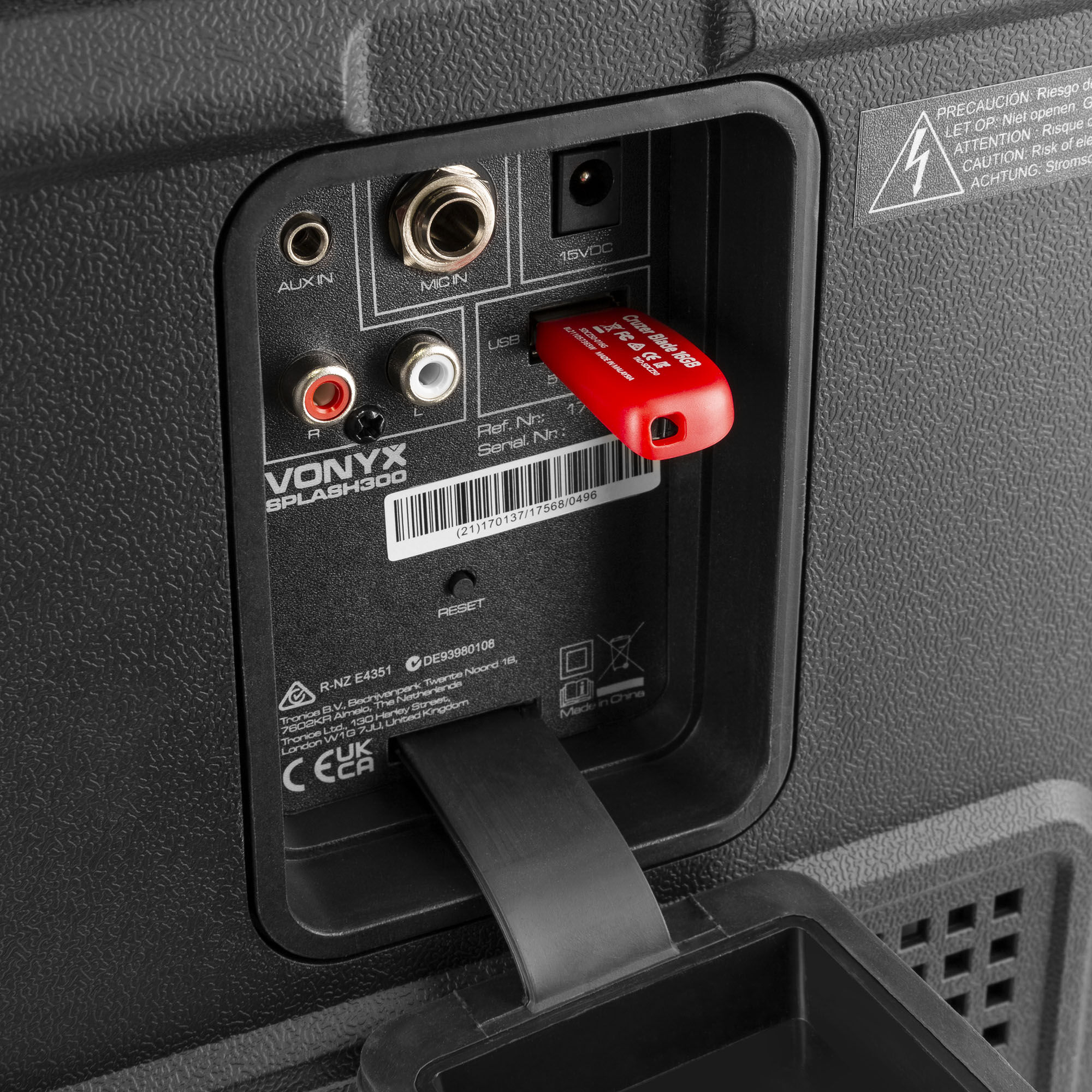 De achterkant van een zwarte luidspreker, met verschillende ingangspoorten en een rode USB-stick.