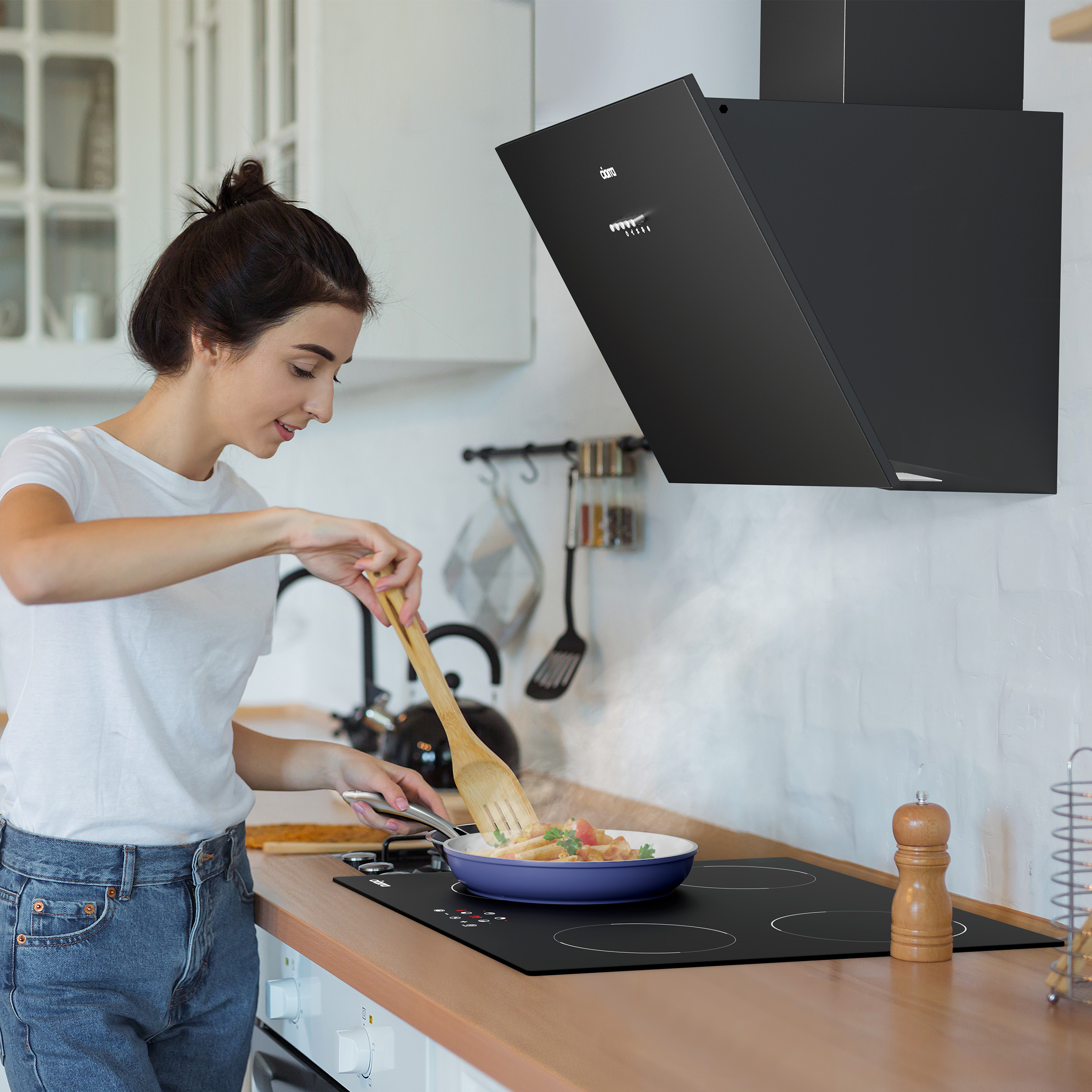 Vrouw die kookt in een keuken. Ze gebruikt een houten lepel. Er is een afzuigkap boven.