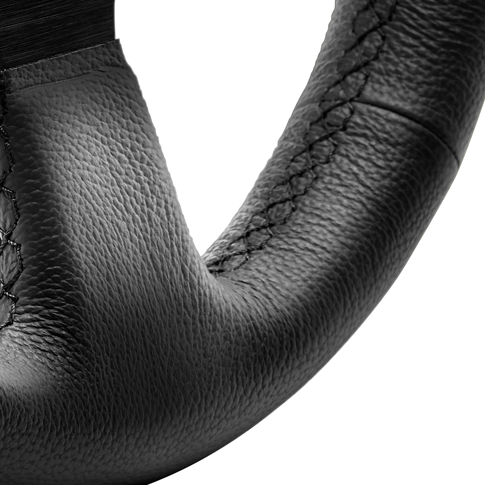 Gros plan d'un volant en cuir noir. Coutures noires visibles.