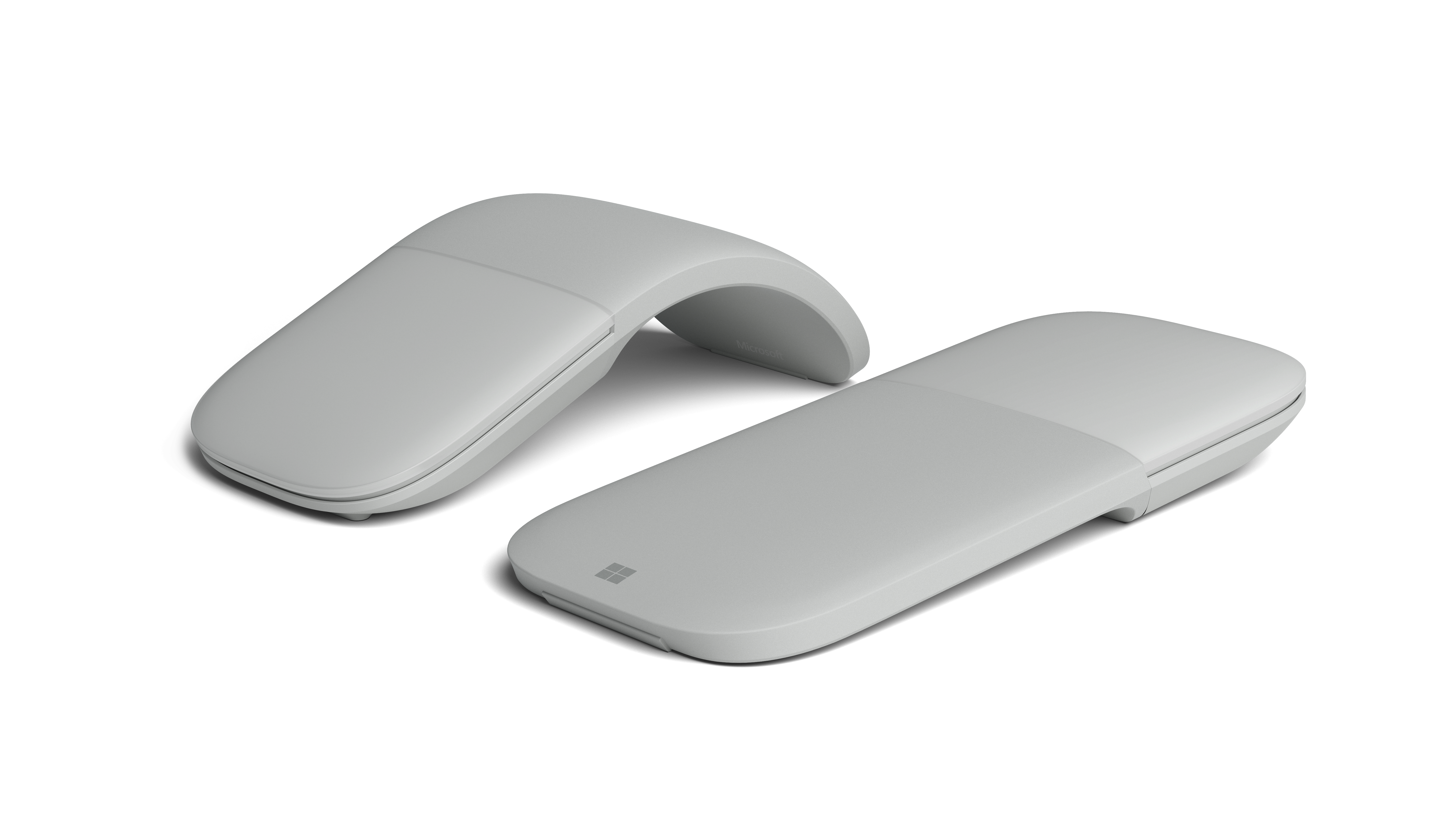 Dwa szare urządzenia Microsoft Surface Arc Mouse; jedno płaskie, jedno łukowate.