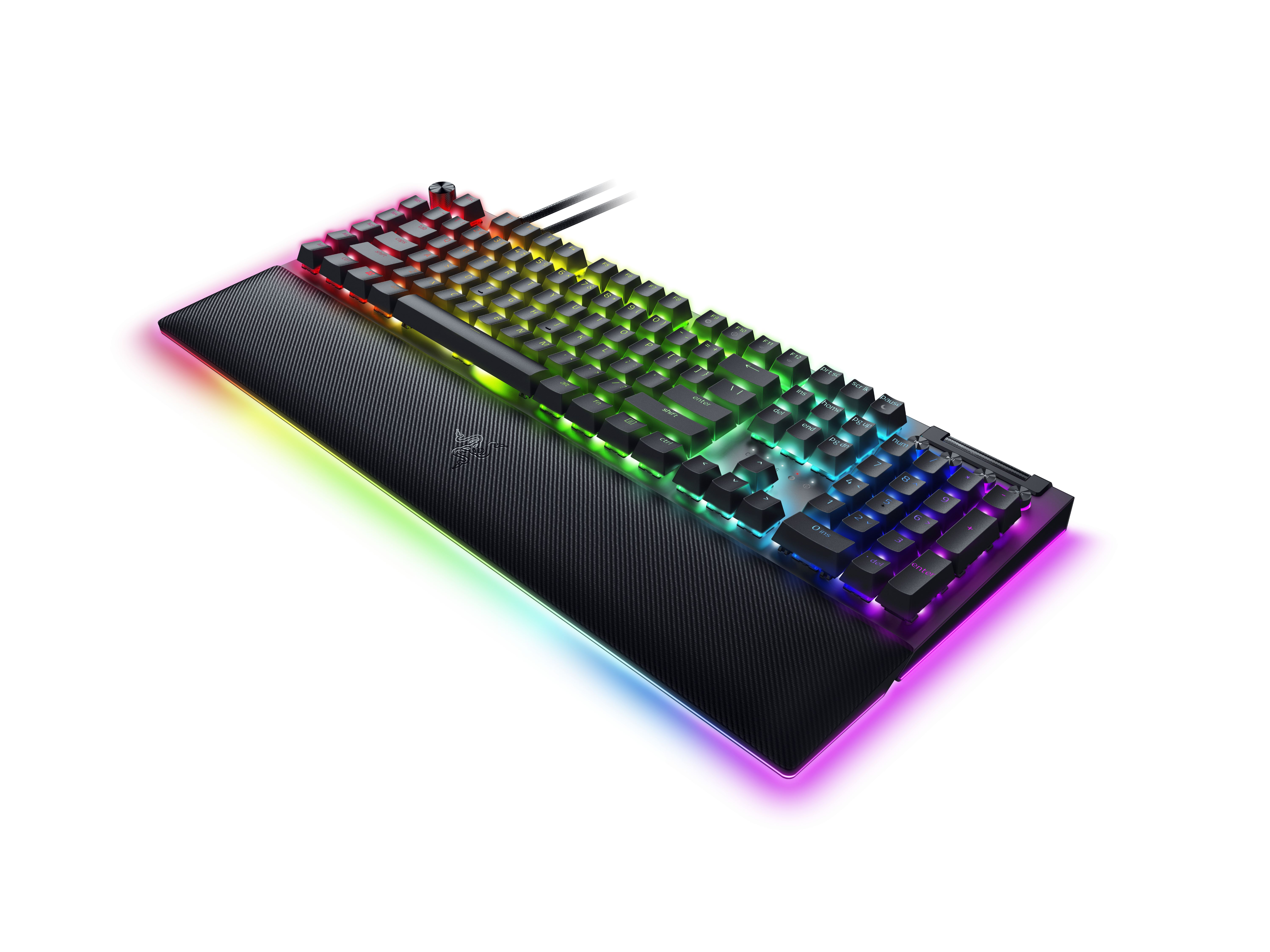 Una tastiera da gioco nera con tasti arcobaleno e poggiapolsi su superficie bianca.