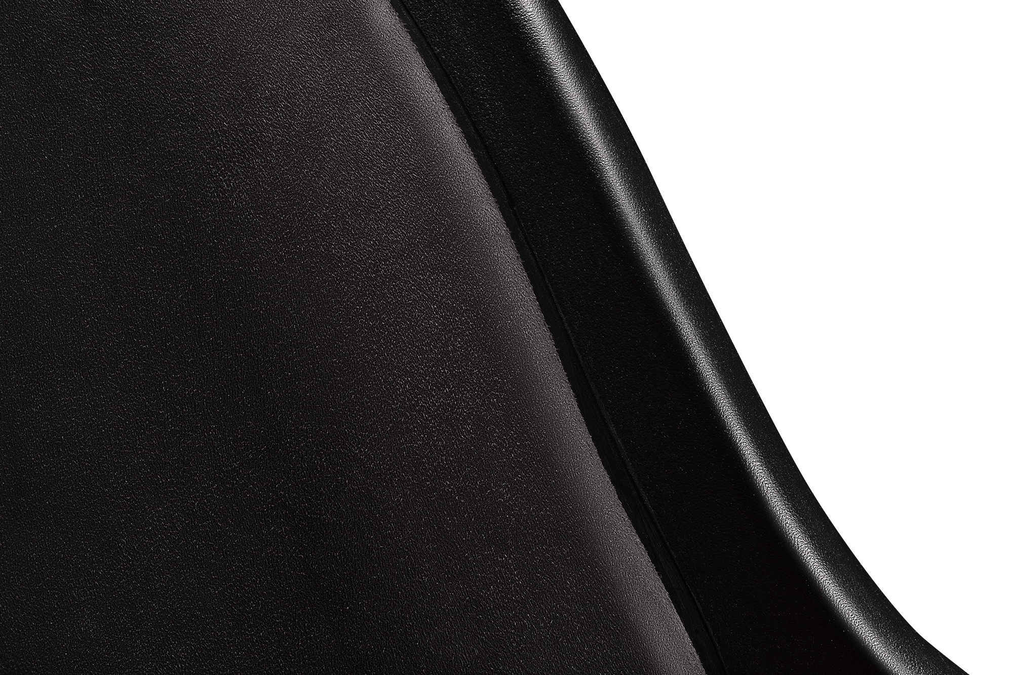 Primer plano de una silla de cuero negro. El cuero es liso y brillante. Fondo blanco.