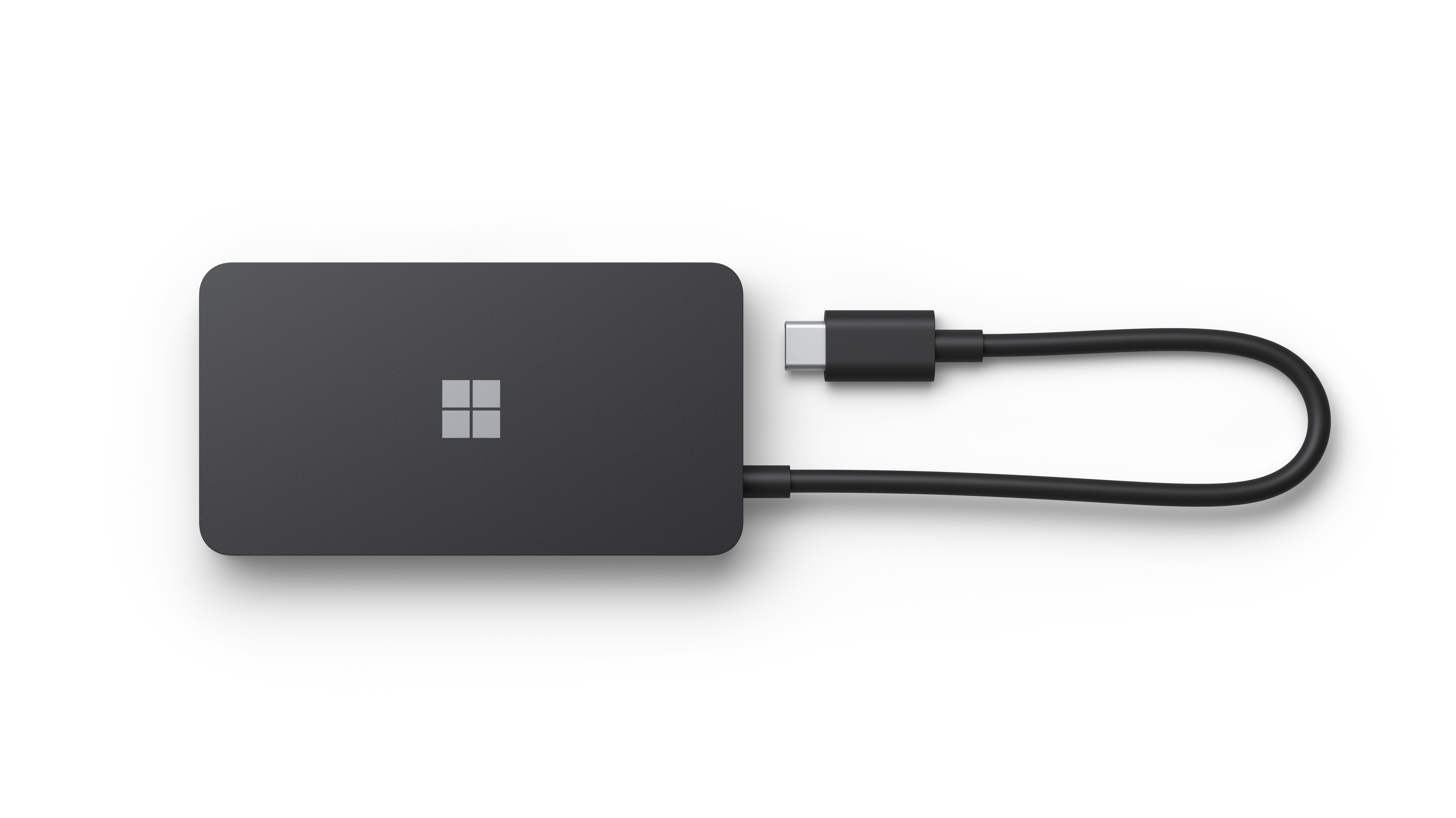 Un hub Surface nero di Microsoft con cavo USB-C su sfondo bianco.