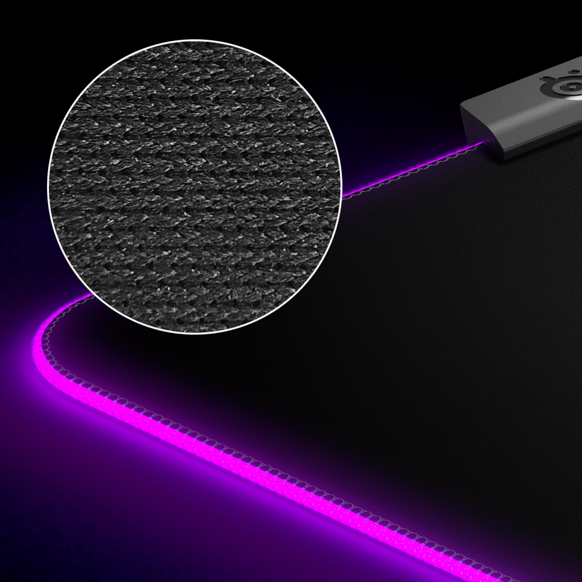 Close-up of a black mousepad with a textured surface and a glowing pink border.