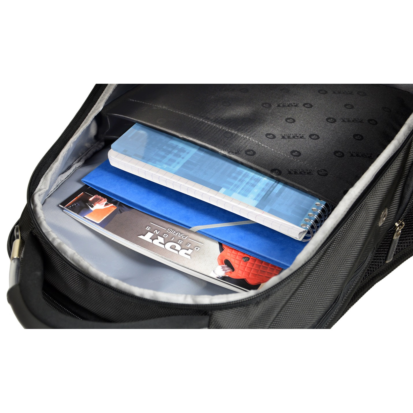 Black backpack open, revealing notebooks and a magazine.