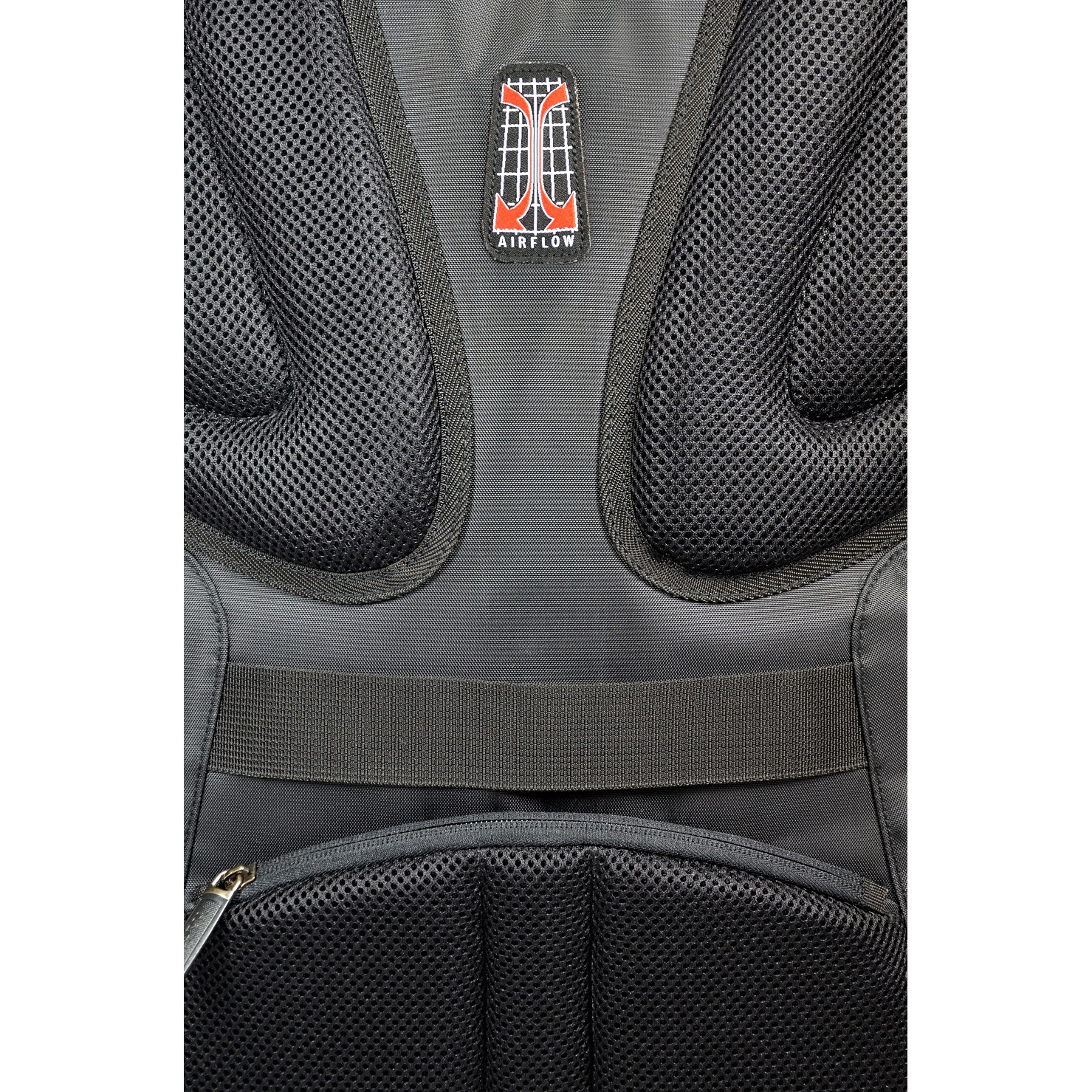 Back of a black backpack with mesh and a red logo. White background.
