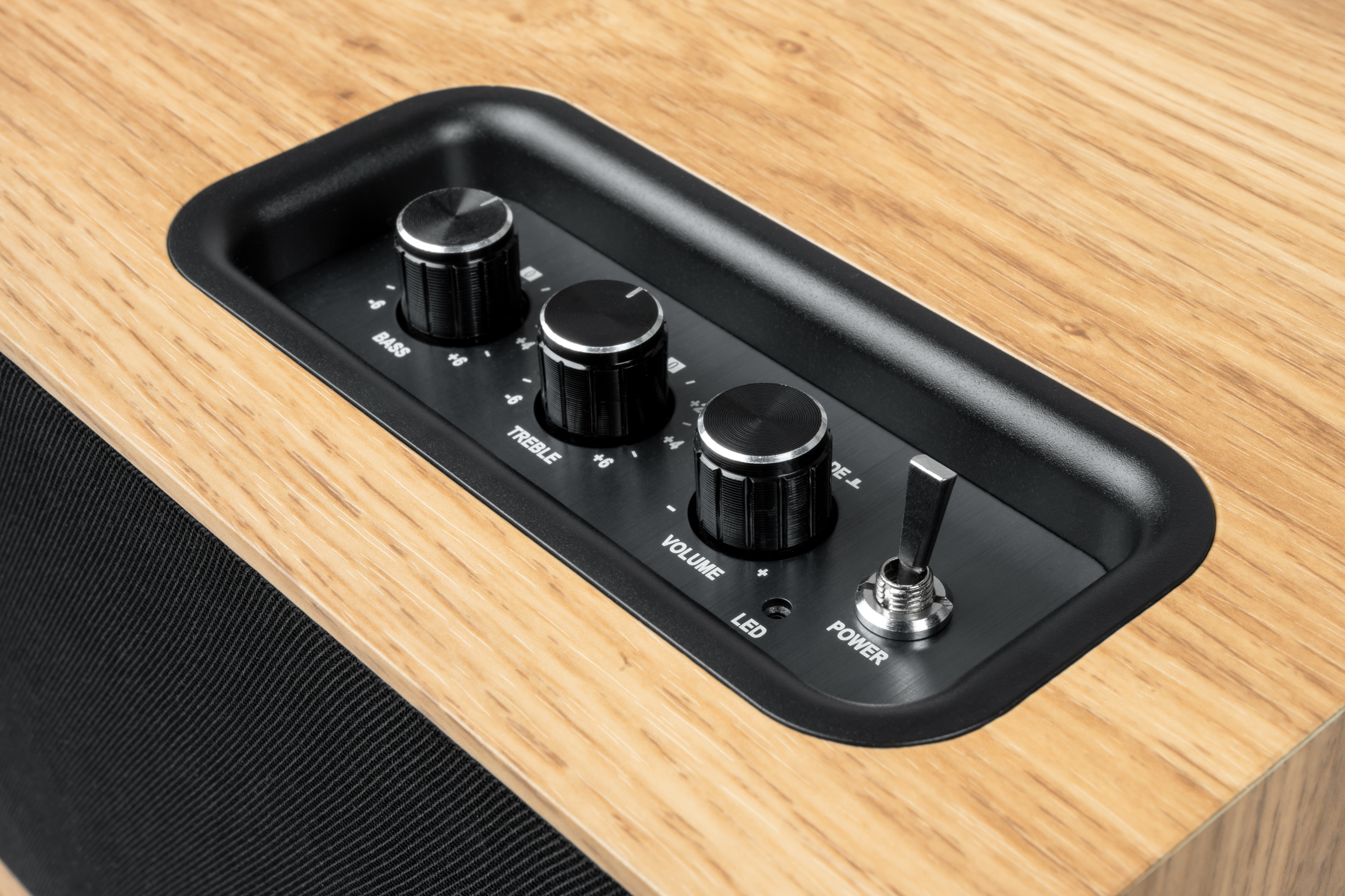 Panel sterowania z pokrętłami basów, tonów wysokich, głośności i włącznikiem zasilania.