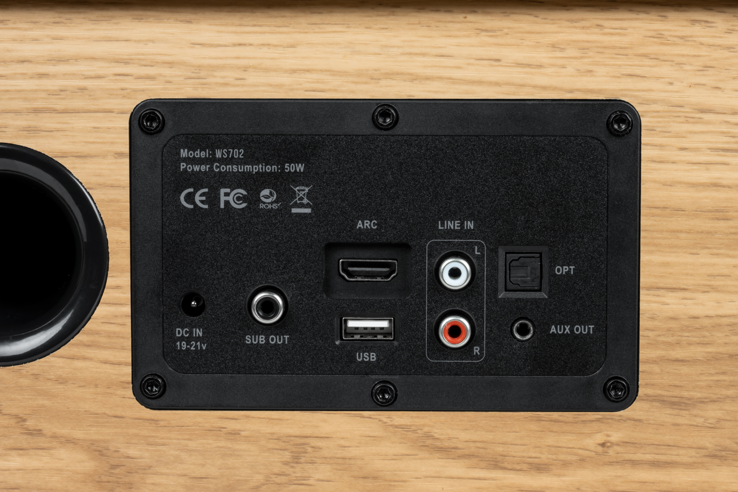 Panel tylny głośnika z drewna z wejściami i wyjściami, w tym USB i HDMI.