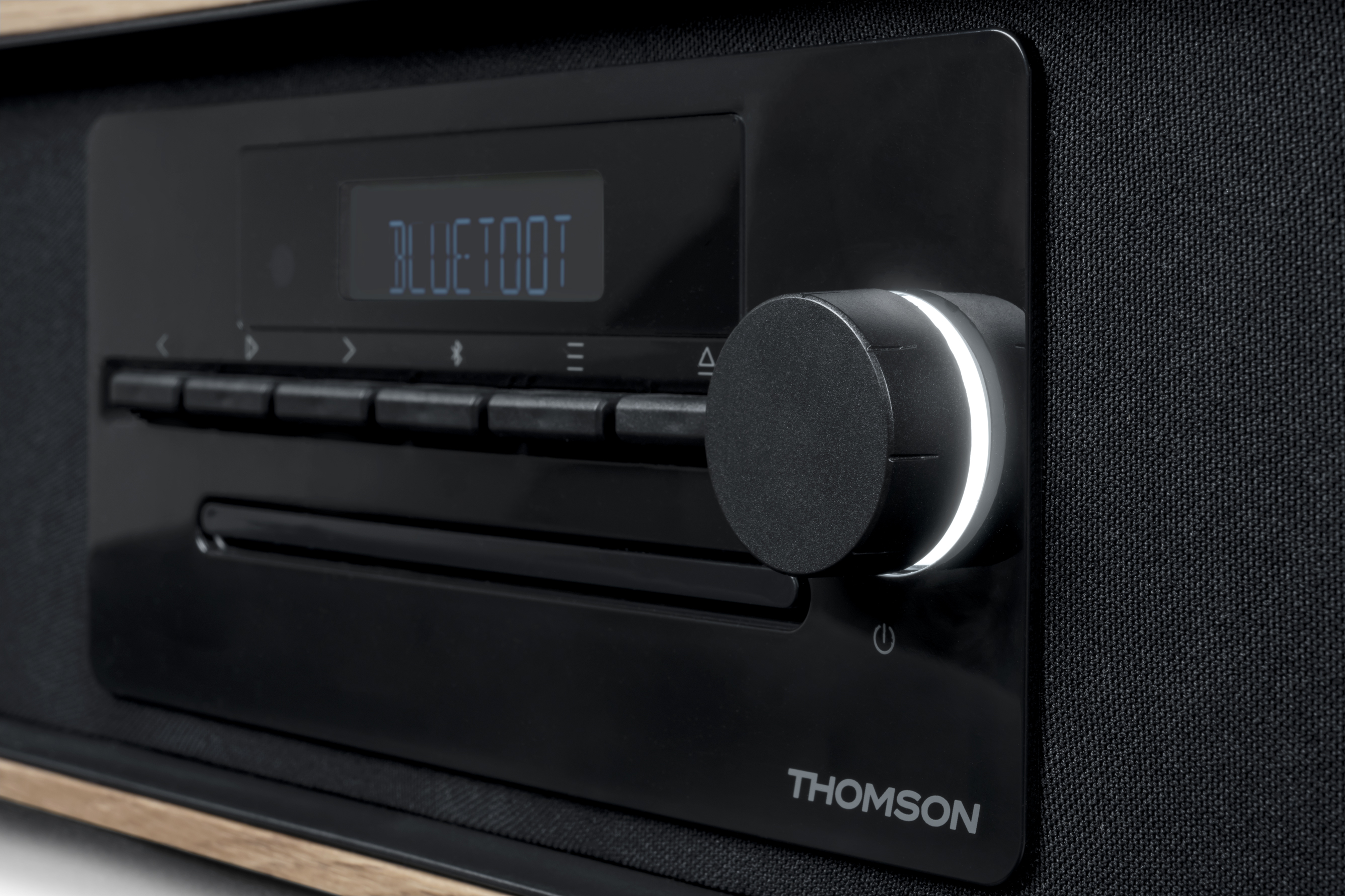 Zbliżenie czarnego panelu sterowania radiem z pokrętłem głośności i wyświetlaczem cyfrowym.