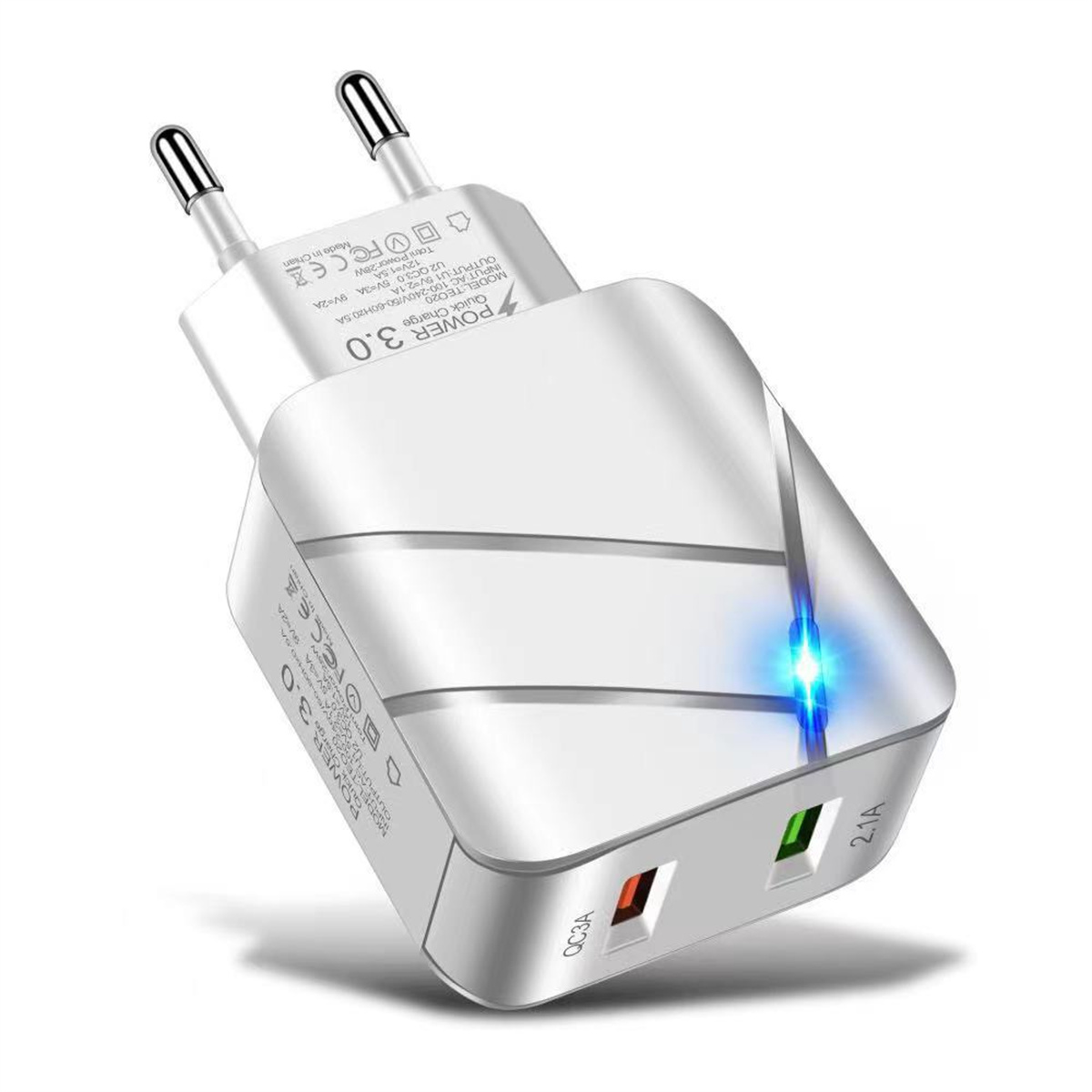 Weißes und silbernes Ladegerät mit zwei Steckern und zwei USB-Anschlüssen. Es ist eingesteckt.