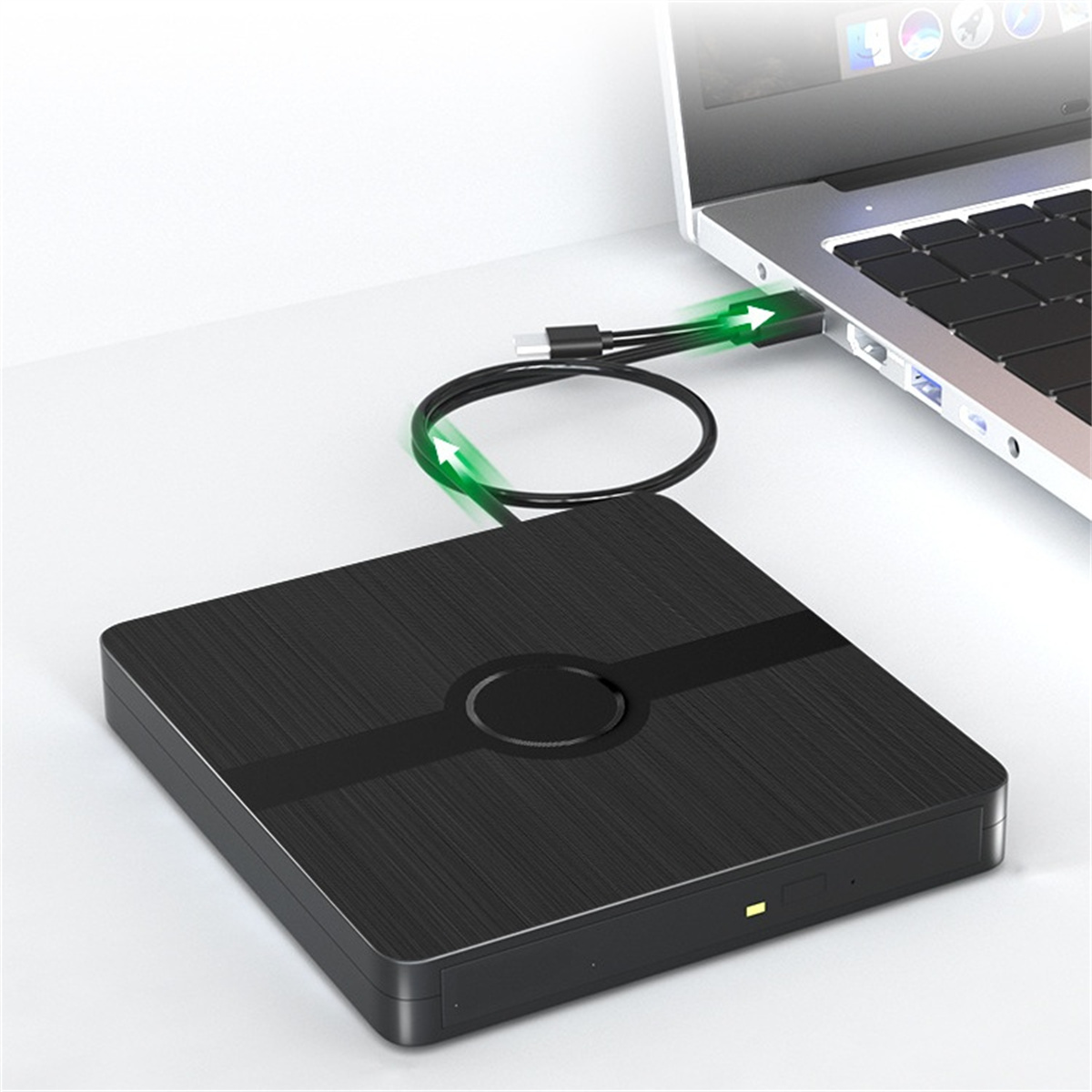 Ein schwarzes quadratisches Gerät, das über ein USB-Kabel mit einem Laptop verbunden ist.