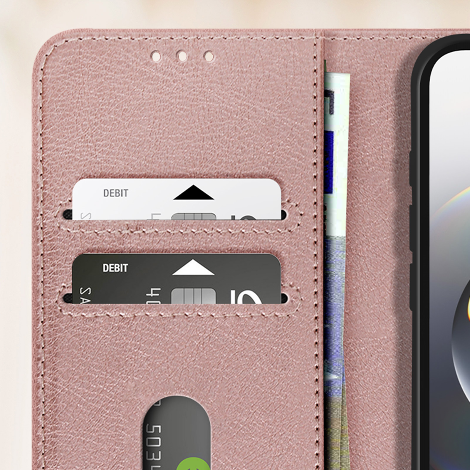Custodia rosa per telefono aperta con carte di debito e denaro. Il telefono è a destra.