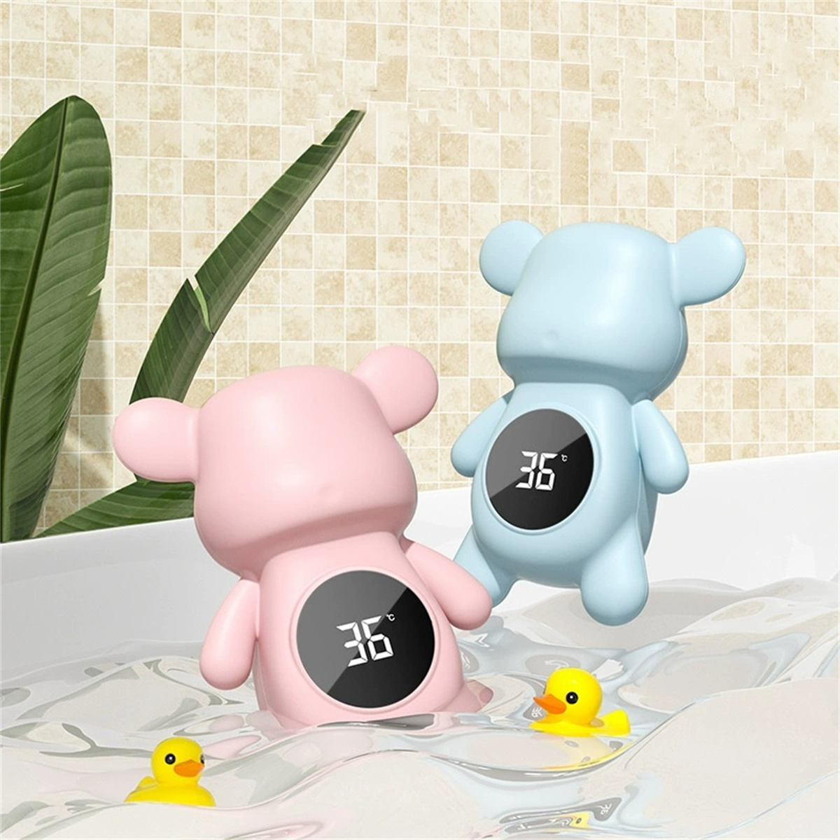Zwei bärenförmige Badethermometer, rosa und blau, in Wasser mit zwei gelben Quietscheenten.