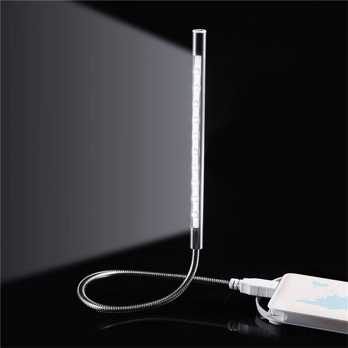 Eine flexible LED-Lampe mit USB-Anschluss, die Licht auf eine dunkle Oberfläche wirft.