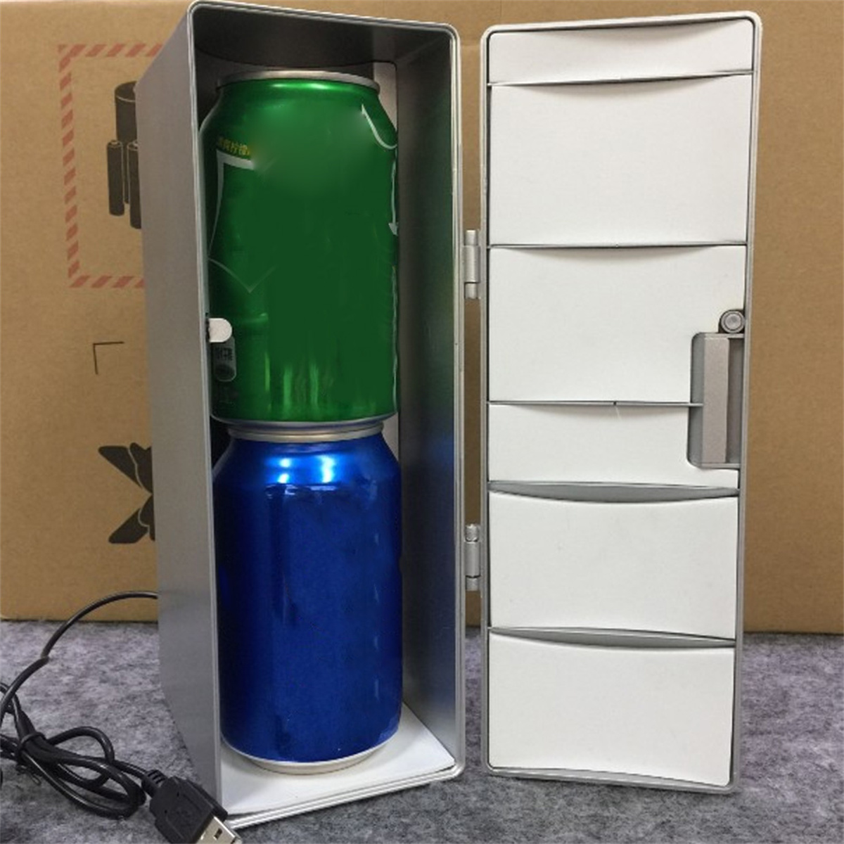 Kleiner silberner Kühlschrank mit grünen und blauen Dosen und USB-Kabel.