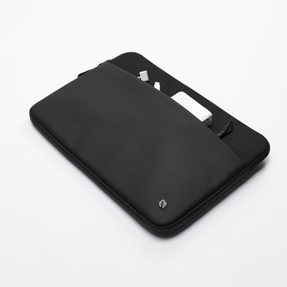 Custodia nera per laptop con una piccola tasca, e alcuni oggetti visibili, su sfondo bianco.