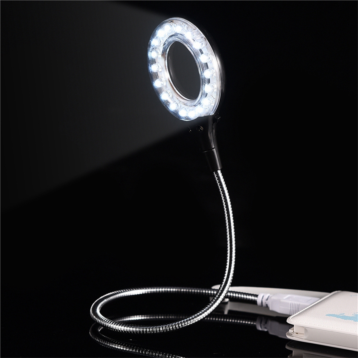 Ein Ringlicht mit weißen LEDs, einem flexiblen Hals und einem USB-Anschluss, vor schwarzem Hintergrund.