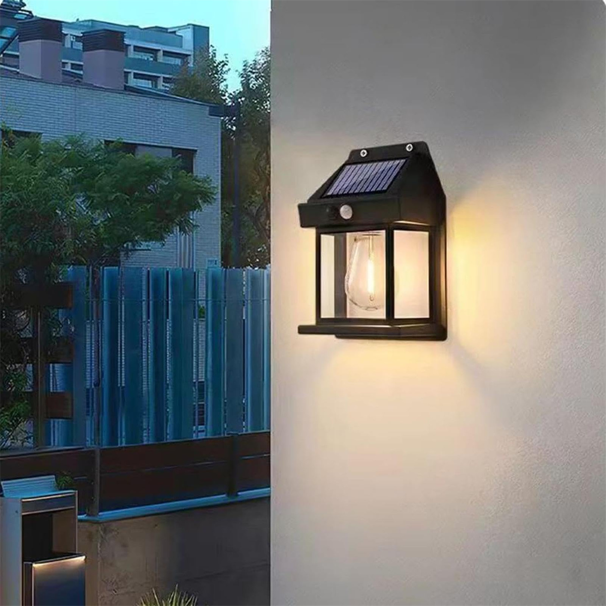 Eine schwarze, solarbetriebene Außenleuchte an einer Wand montiert. Das Licht ist an.