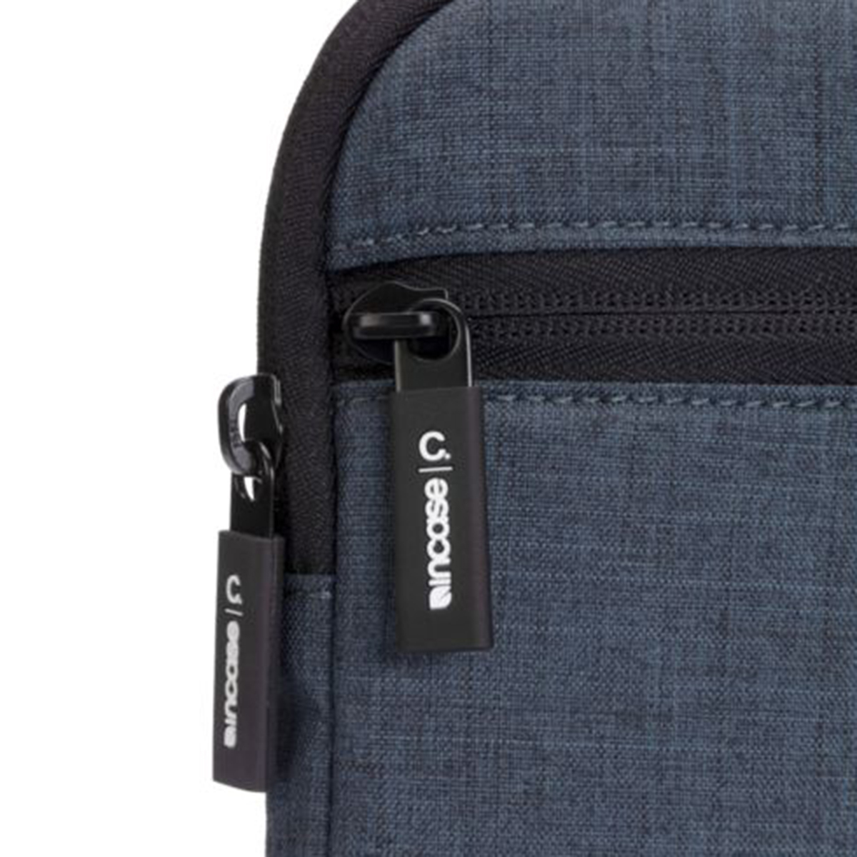Primo piano di una borsa blu scuro con cerniera nera ed etichetta del marchio.