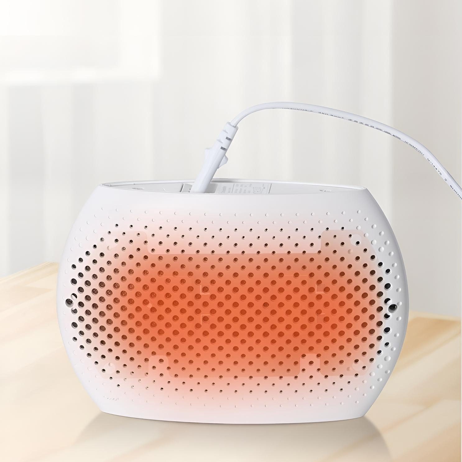 Weißer, oval geformter Heizlüfter mit rotem Leuchten im Inneren und vielen Löchern. Weißes Kabel.