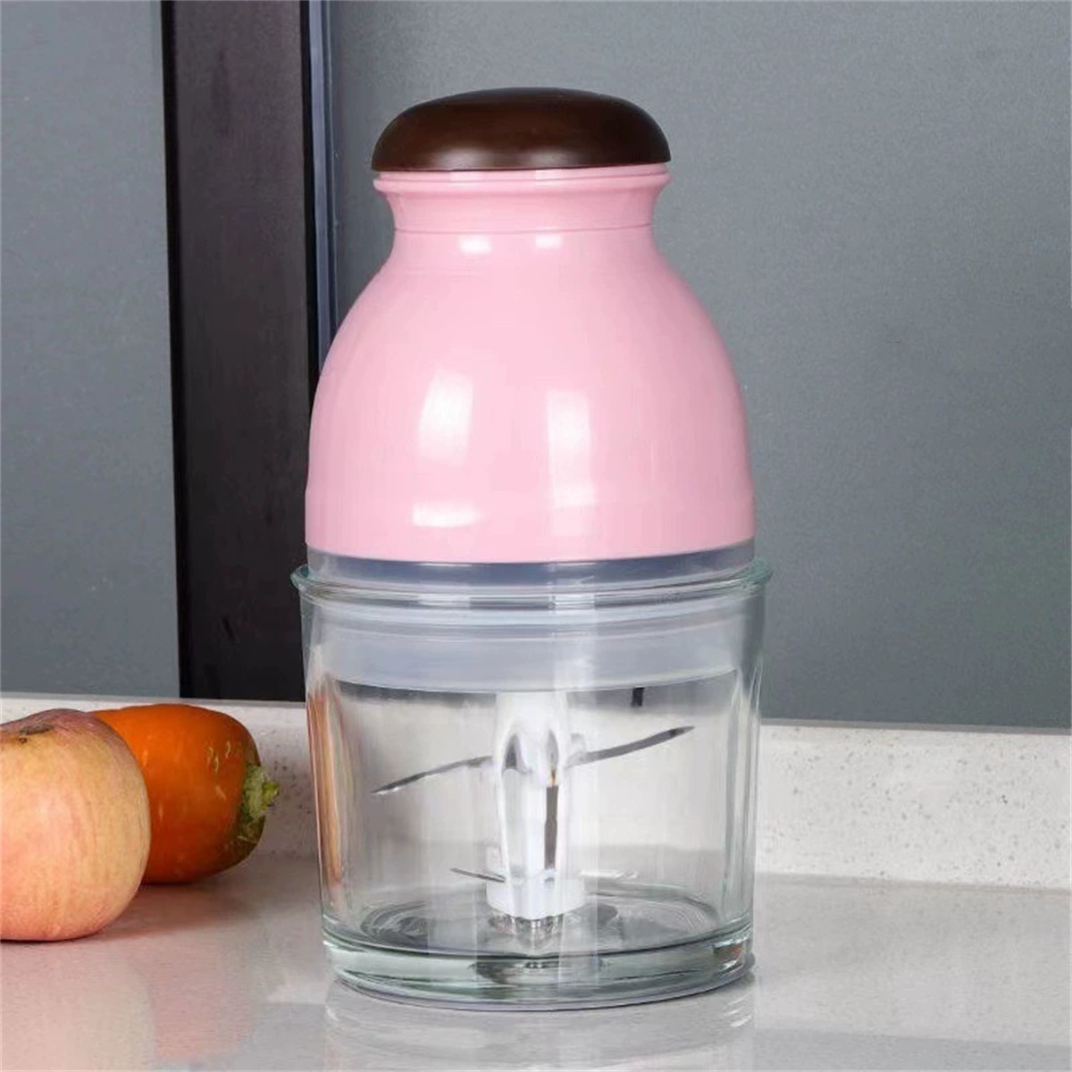 Rosa-brauner Foodprocessor mit Glasbehälter und Klinge darin.
