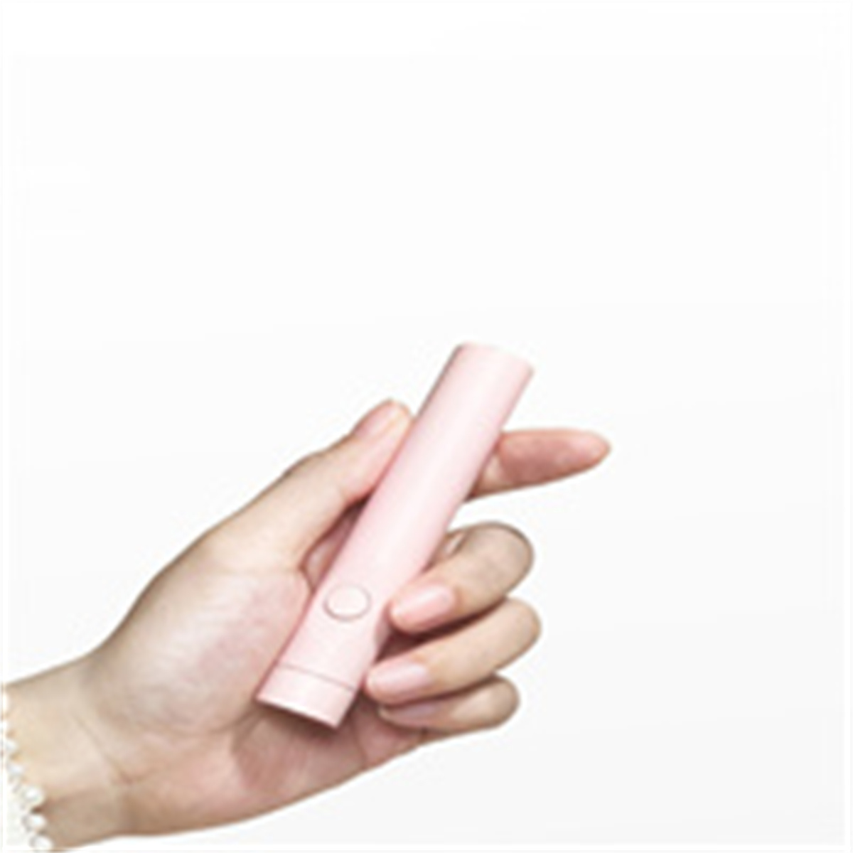 Eine Hand, die einen rosa Stift hält. Ein weißer Hintergrund.