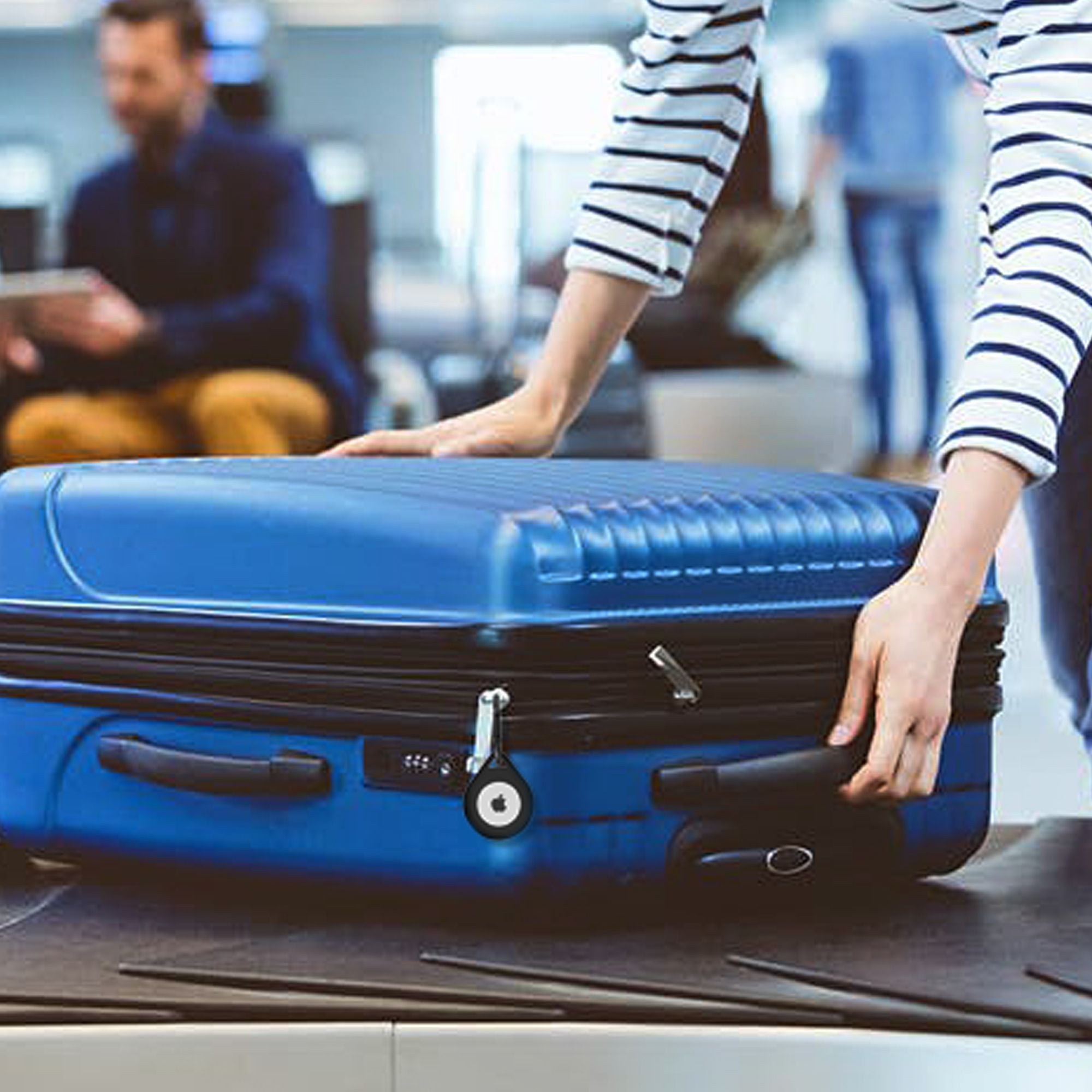 Person am Flughafen-Check-in. Blauer Koffer auf dem Förderband.
