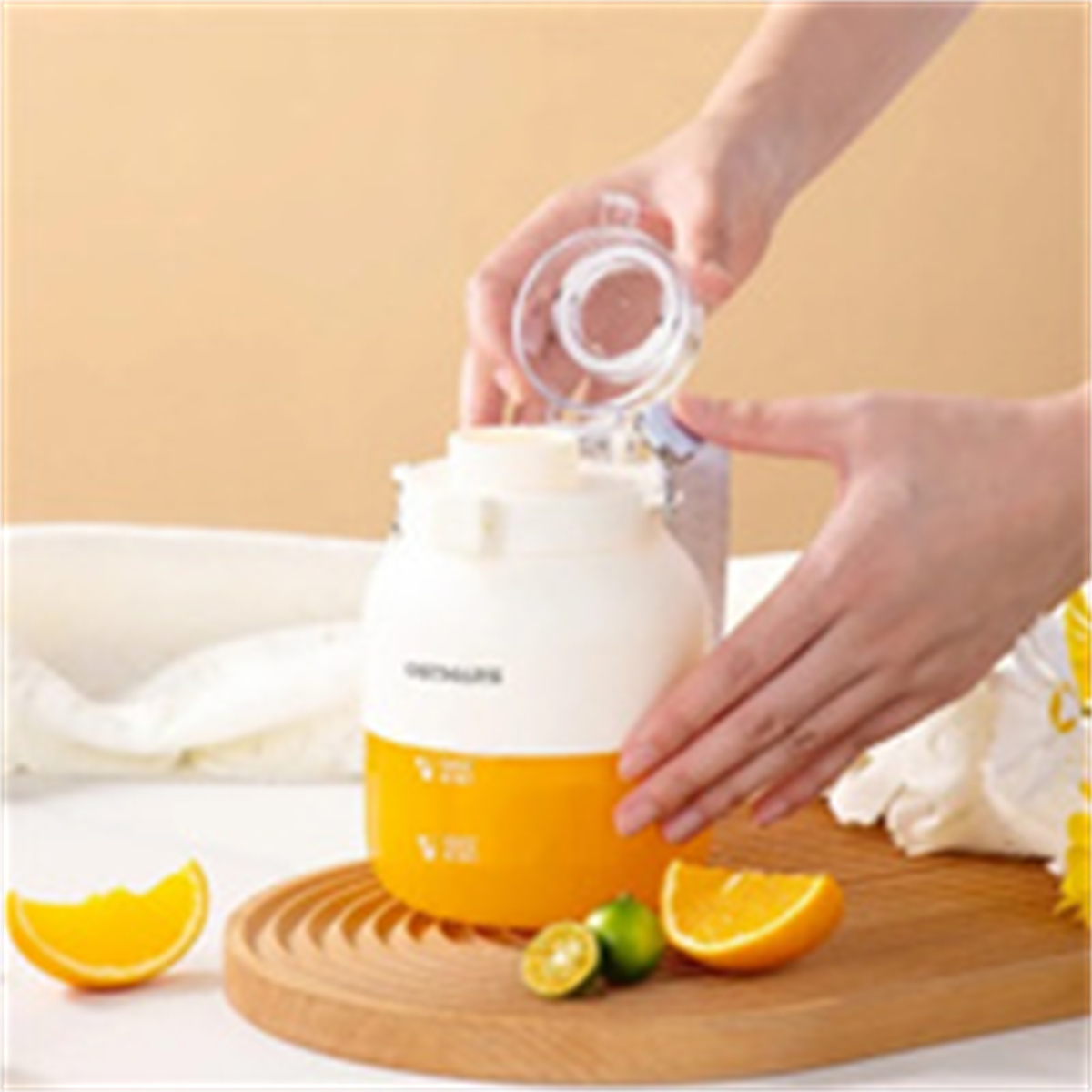 Hände, die ein weißes Glas mit orangener Flüssigkeit halten, Orangen und Limetten auf Holzbrett.