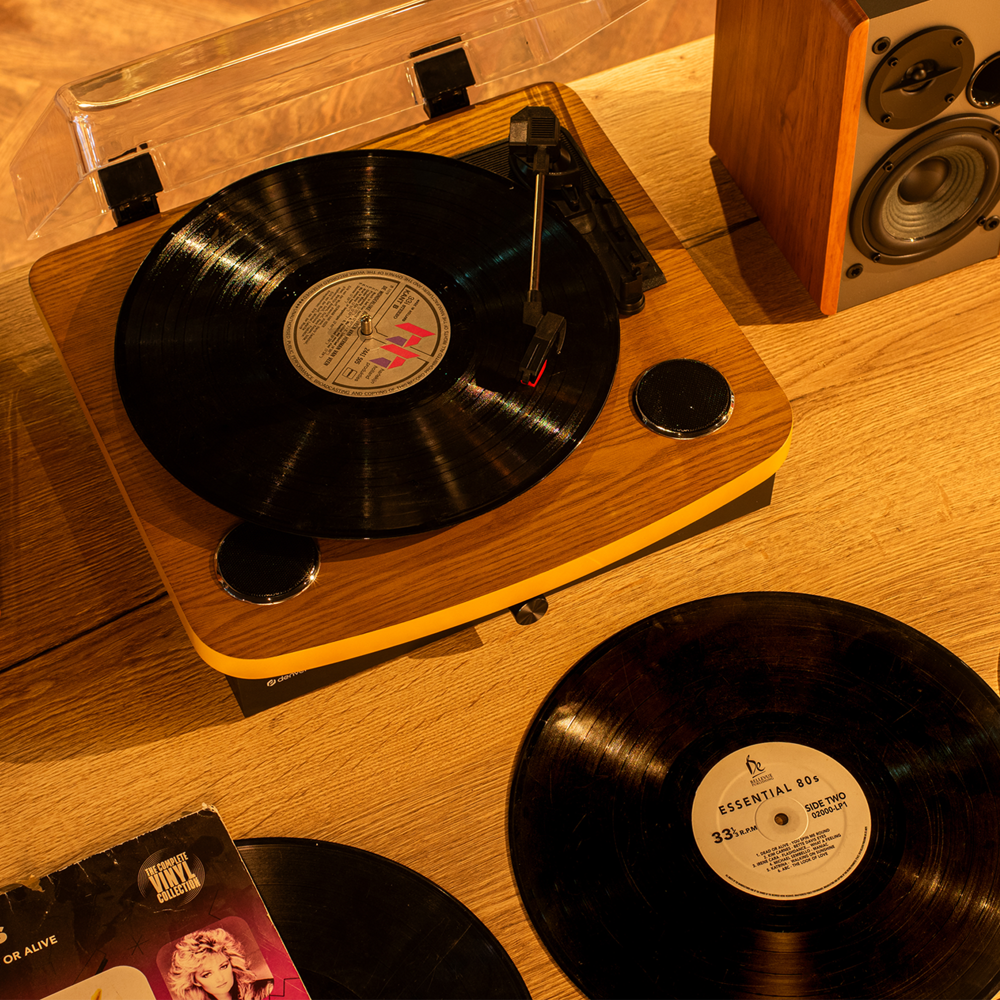 Drewniany gramofon z płytą winylową i głośnikiem w kadrze.