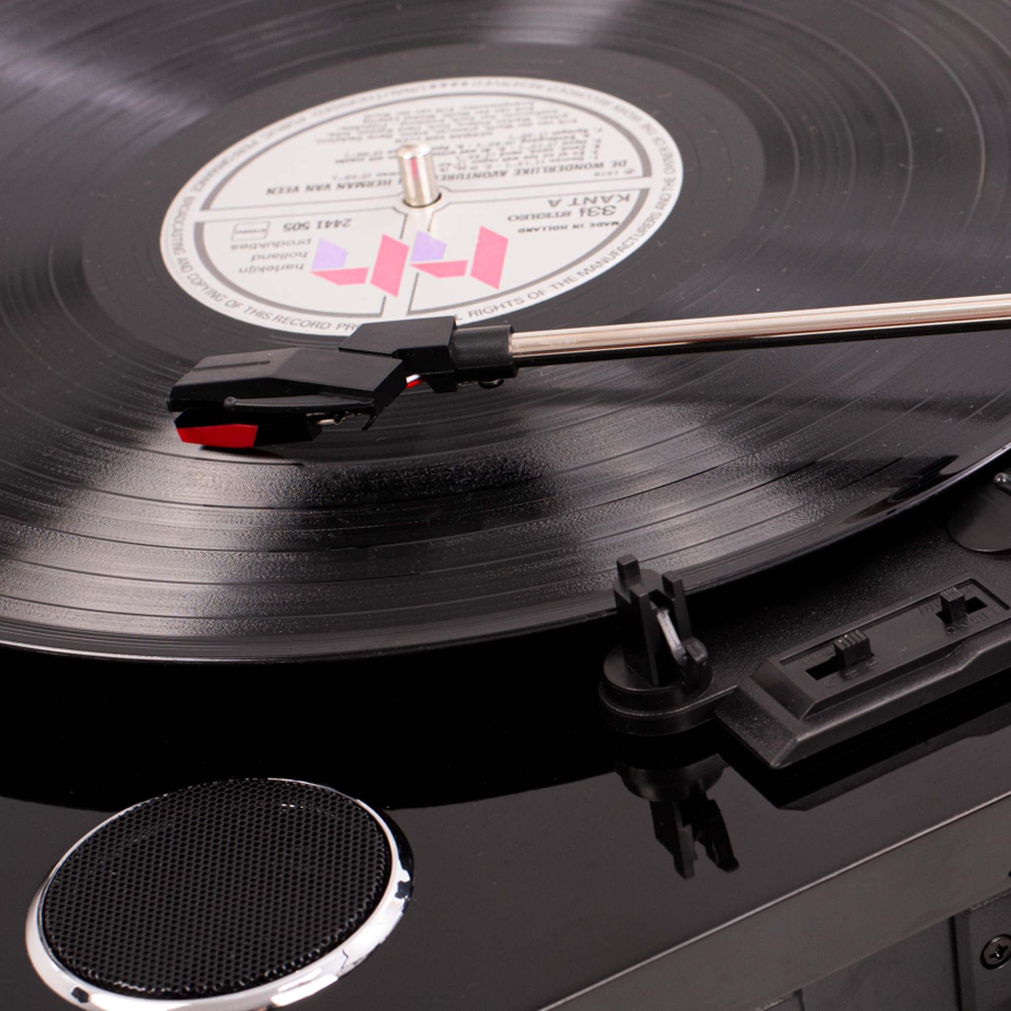 Gramofon z płytą winylową, igłą i głośnikiem, czarne wykończenie.