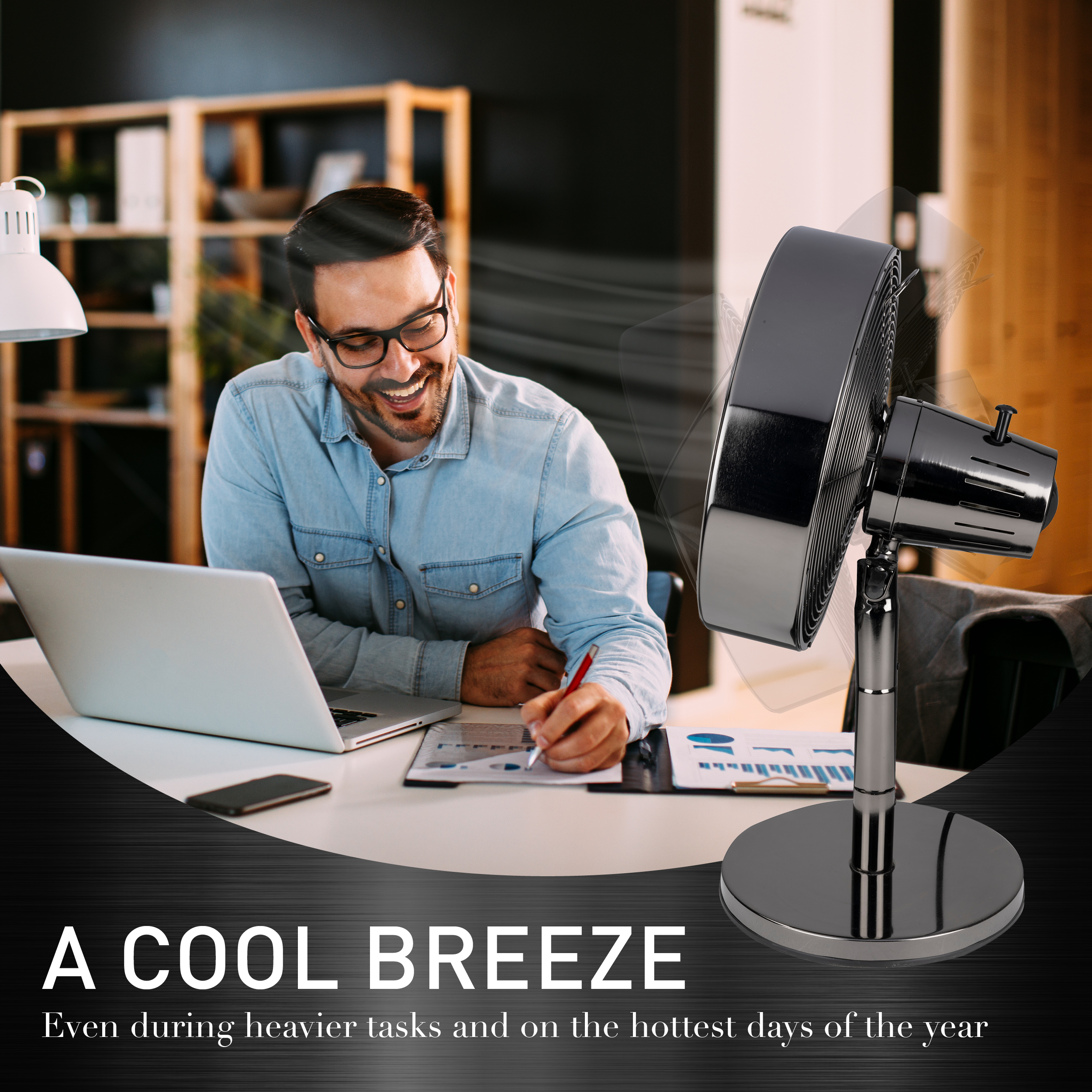 Homme travaillant à son bureau avec un ventilateur. Ordinateur portable, papiers et stylo visibles. Le ventilateur est noir et brillant.
