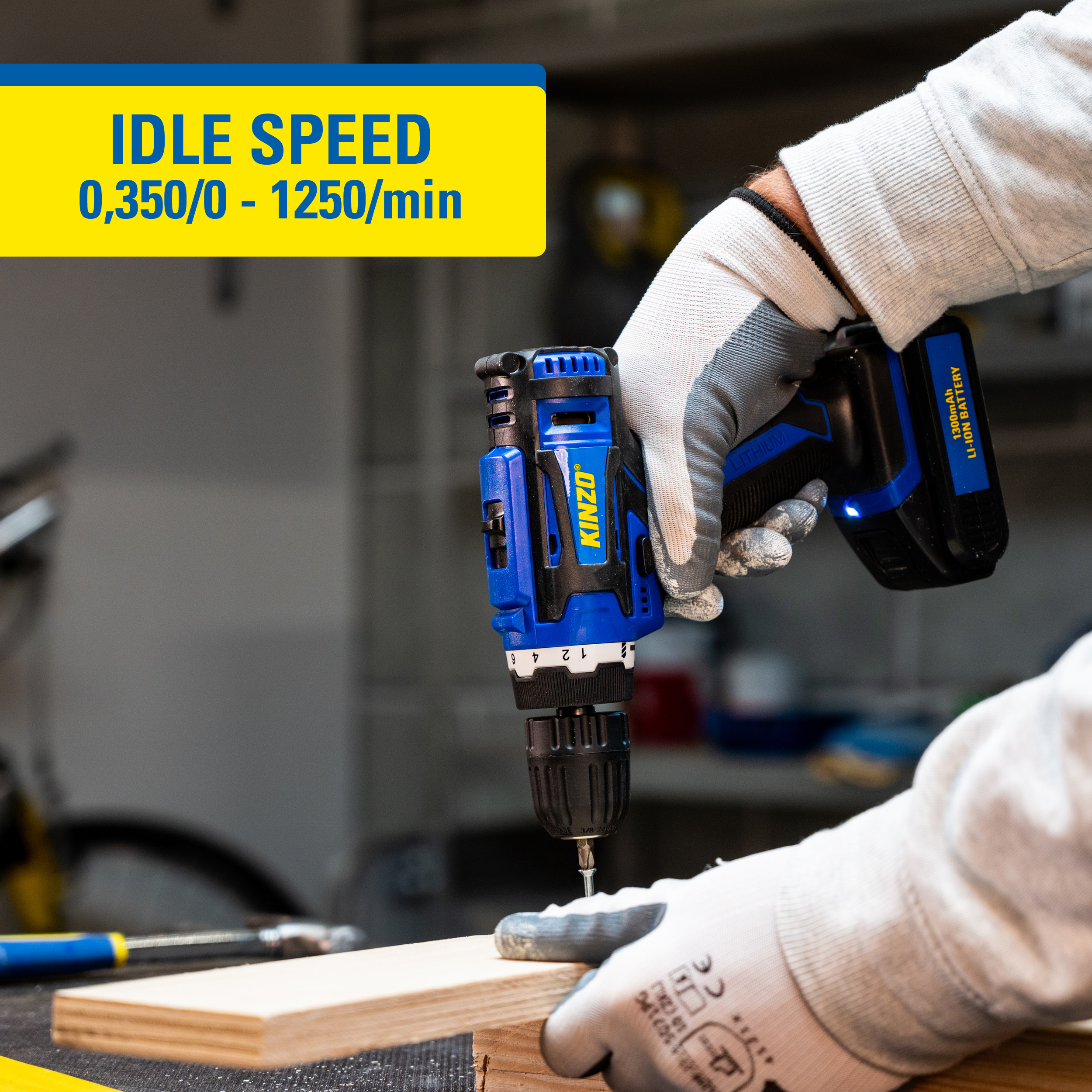 Blauw-zwarte accuboormachine, handen met handschoenen, houten plank.