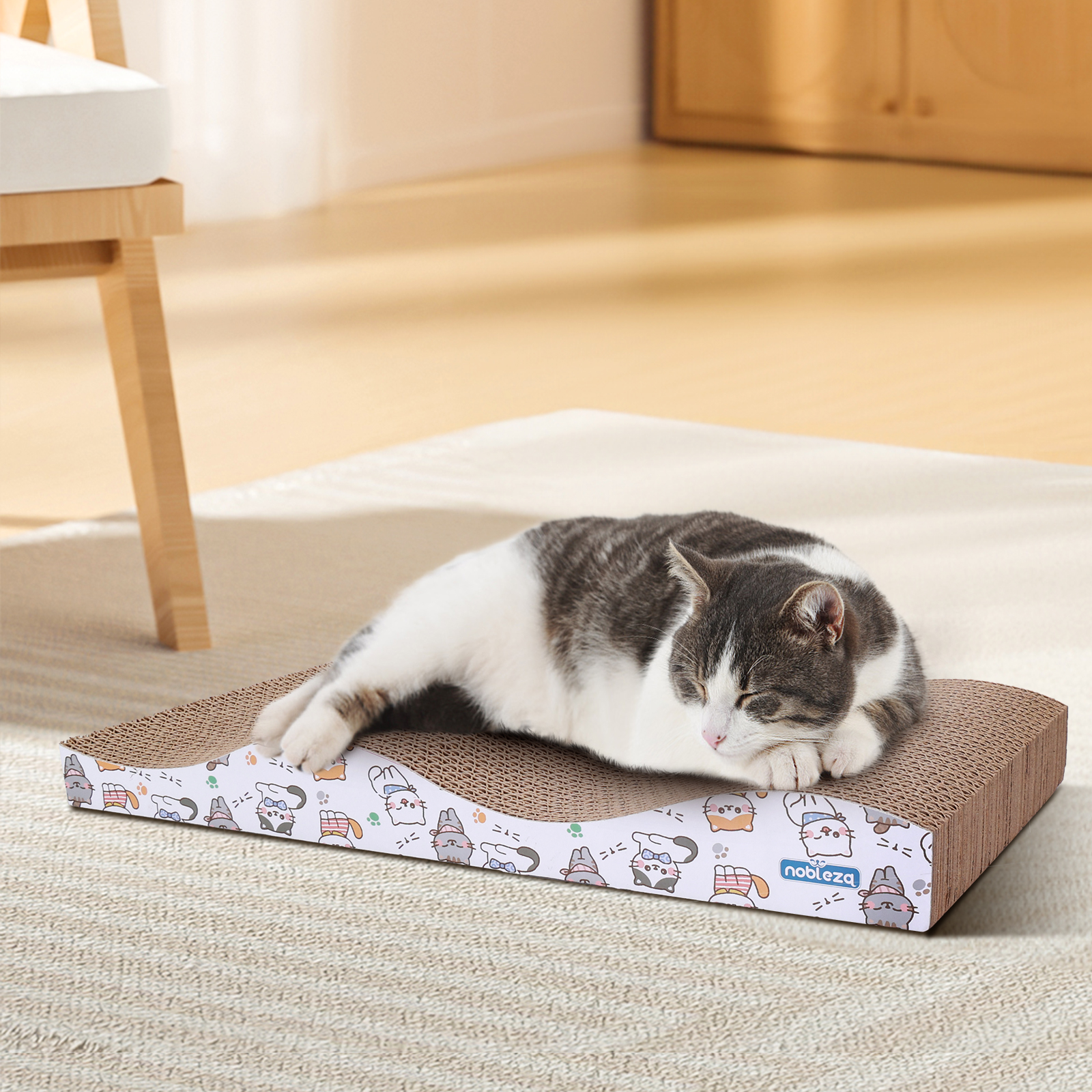 Gato durmiendo en un rascador de cartón. El rascador tiene un patrón impreso.