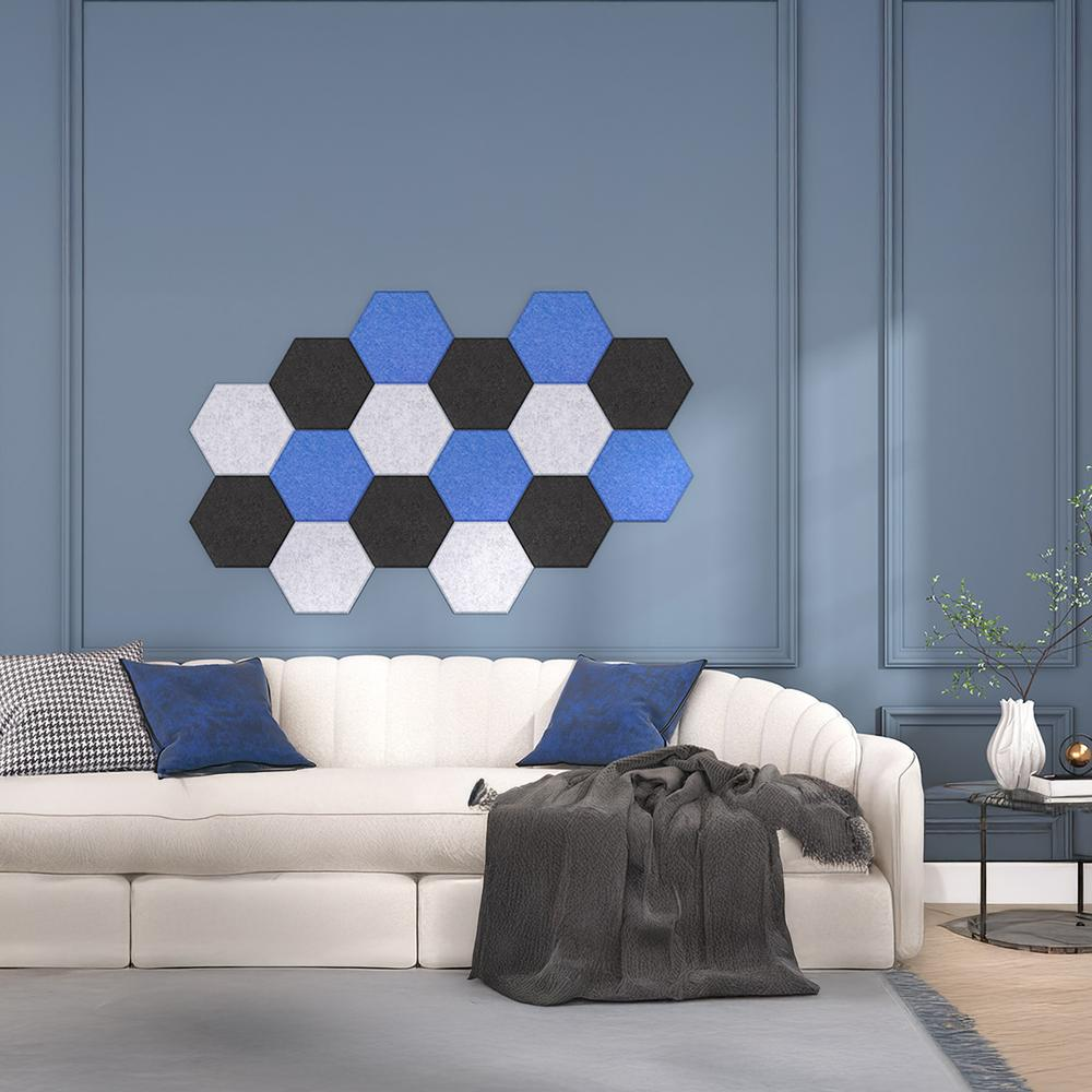 Un sofá blanco con cojines azules y una manta gris contra una pared azul.