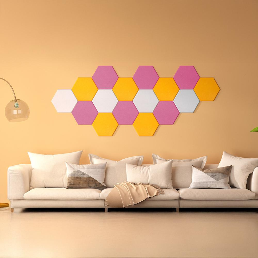 Una sala de estar con un sofá blanco, decoración de pared hexagonal colorida y una pared amarilla.