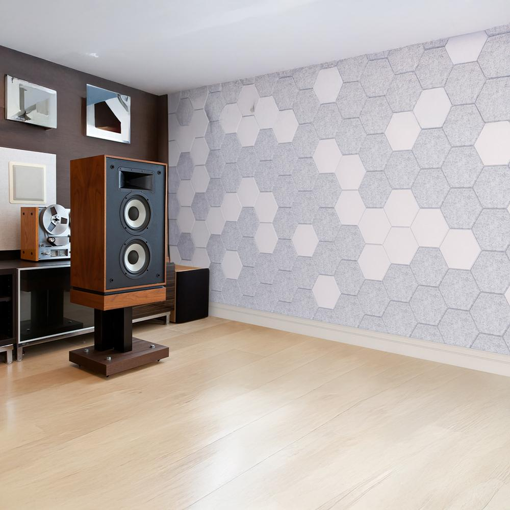 Una habitación con altavoces, paneles de insonorización y tocadiscos en un suelo de madera, que combina tecnología vintage con diseño moderno.