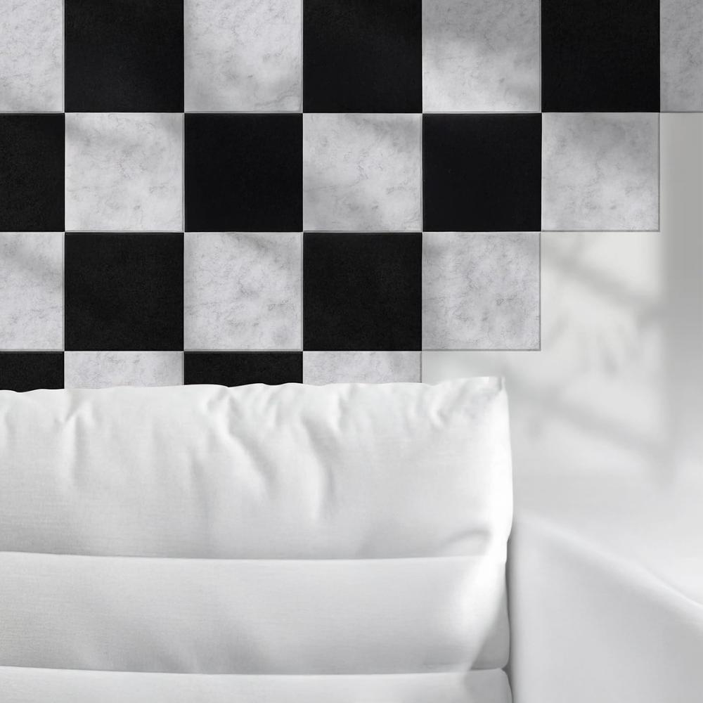 Pared de azulejos blancos y negros con un cojín blanco en la parte inferior, primer plano.