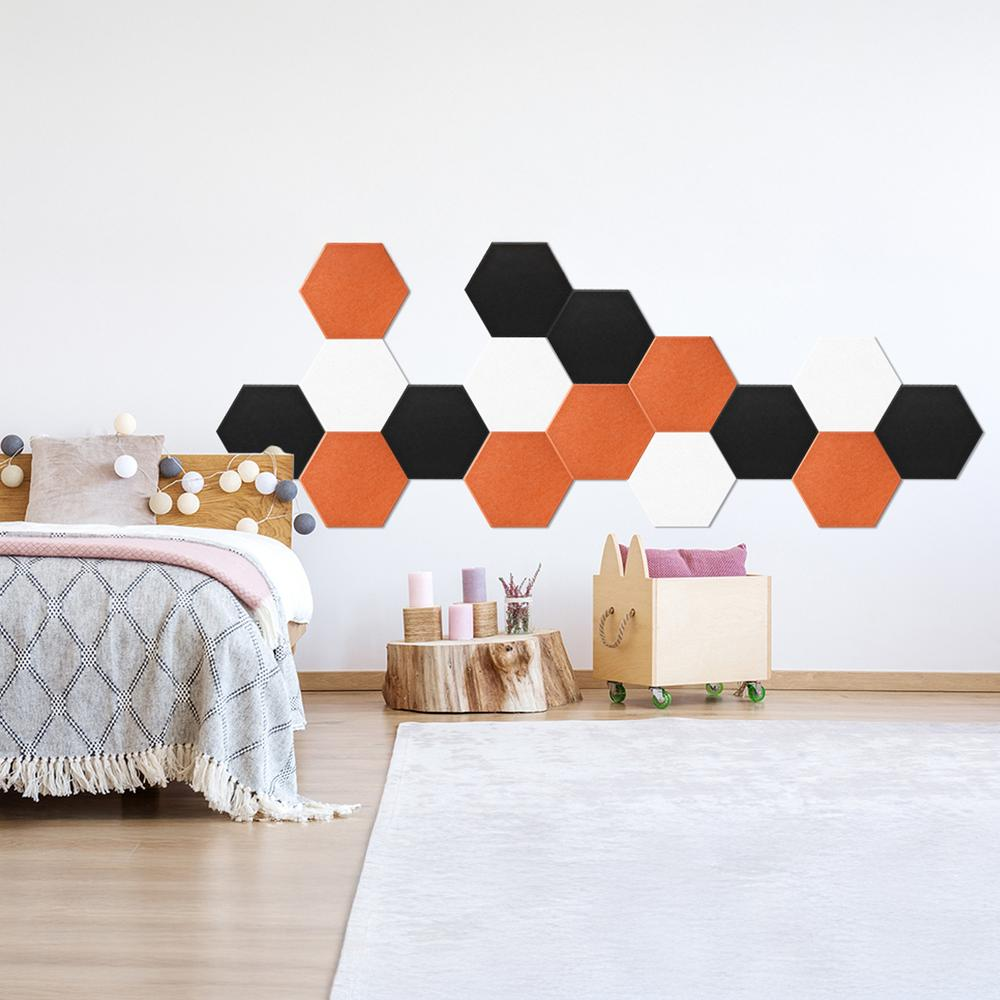 Una pared está decorada con azulejos hexagonales de colores. Una cama y una caja de madera también están en la habitación.